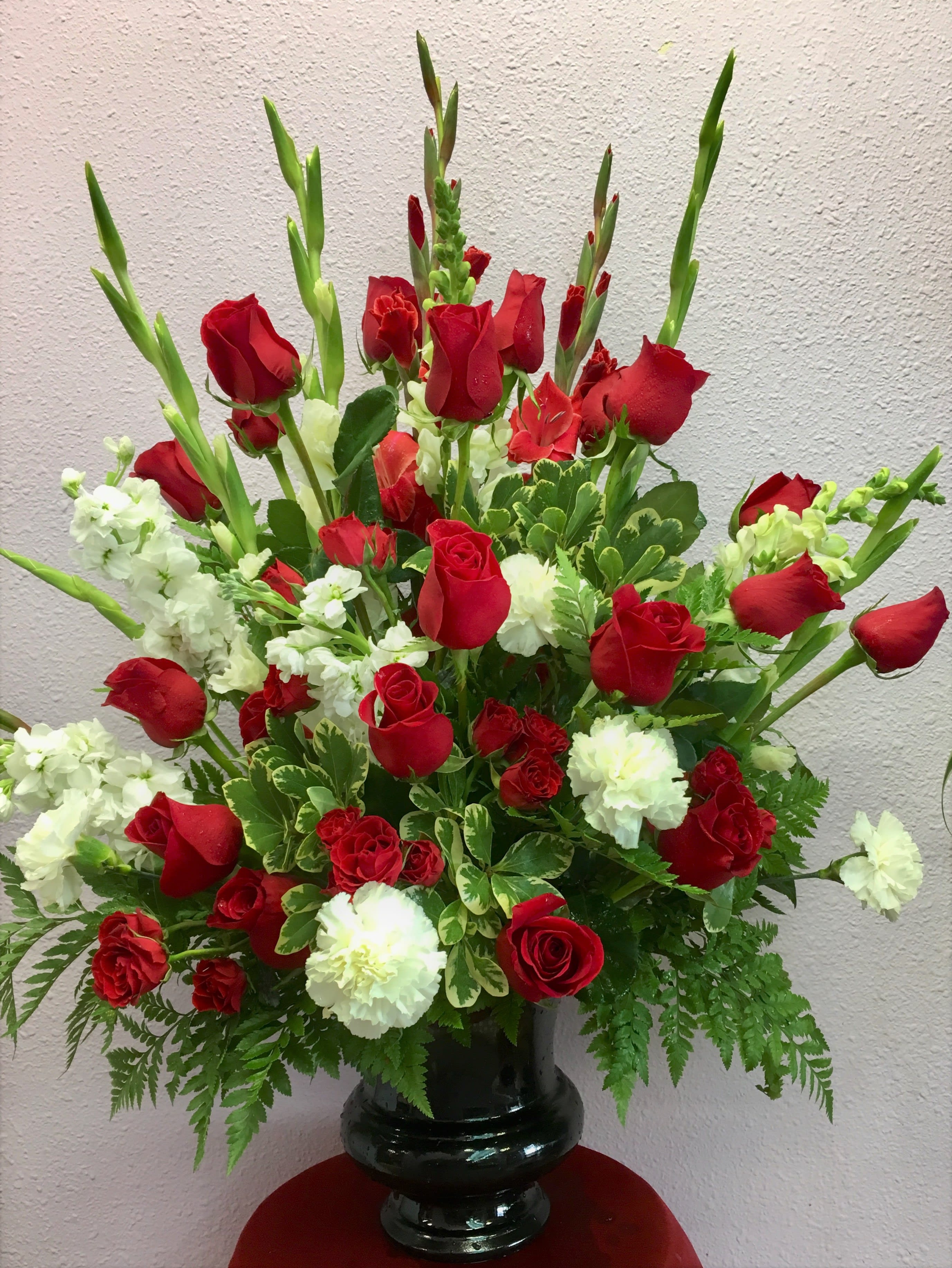 Red roses and white carnations in a black vase