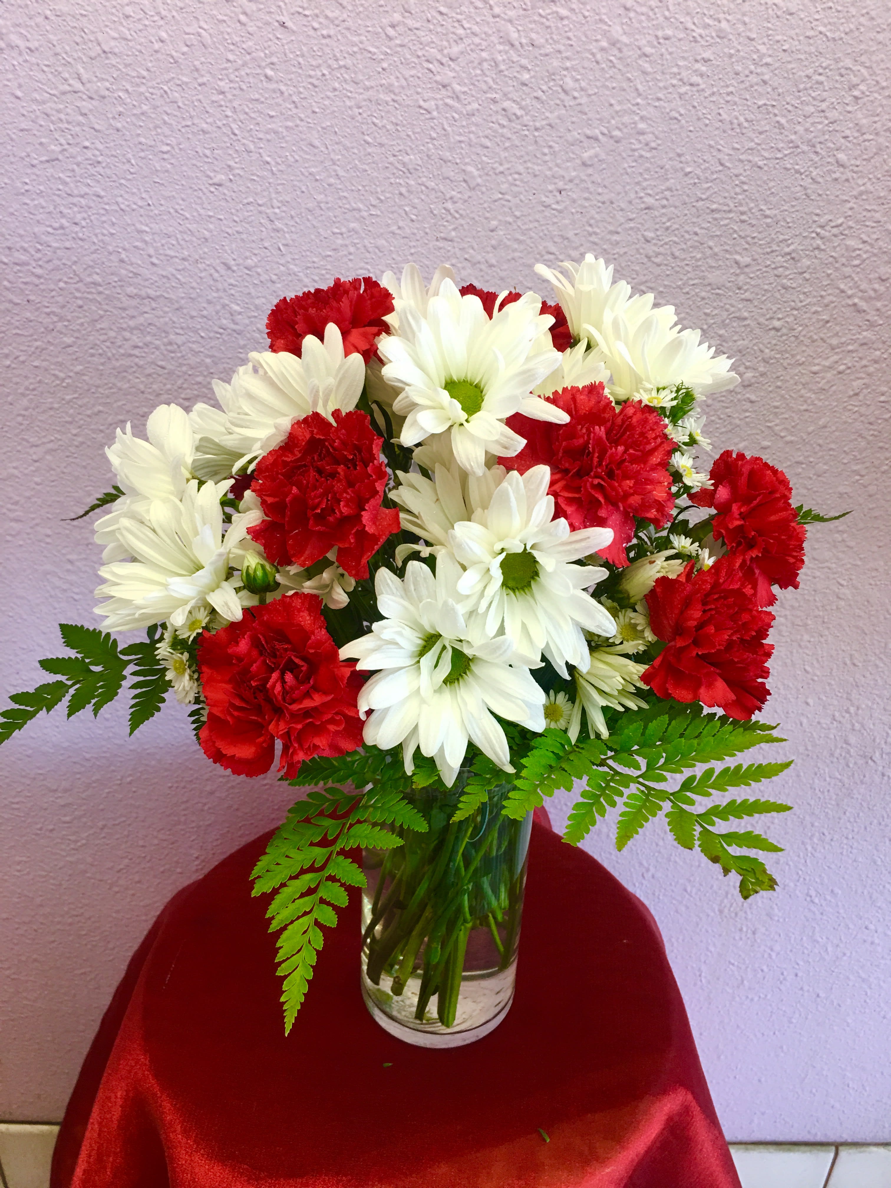 Crazy for Daisies by Forever Flowers - A modest gift that will make a lasting impression. Daisy Crazy by BloomNation™ is the perfect gift for a birthday or just to show you care.   Arrangement Details: Includes white chrysanthemum spray daisies, red carnations, and assorted greenery. APPROXIMATE DIMENSIONS: 12" H X 12" W
