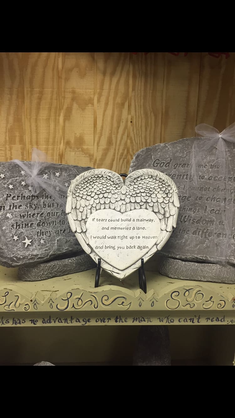 Heart-shaped memorial plaque with angel wings on a stand