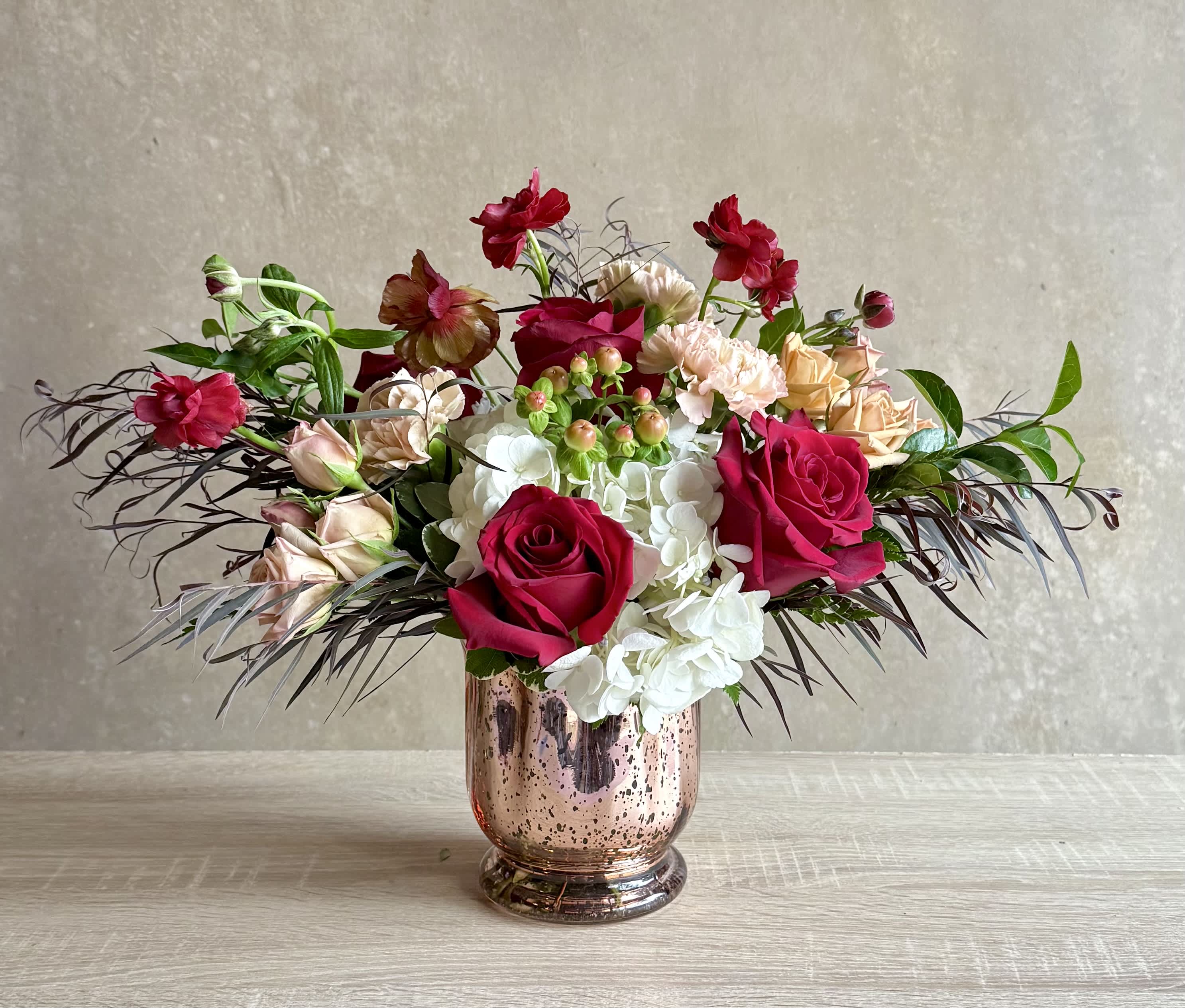 Mixed bouquet of roses and hydrangeas in a metallic vase