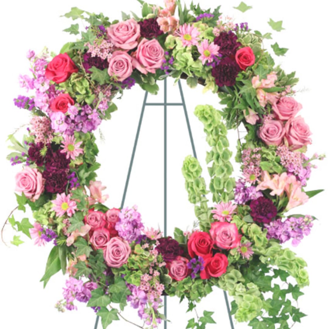 Floral wreath of pink and purple flowers on a metal stand