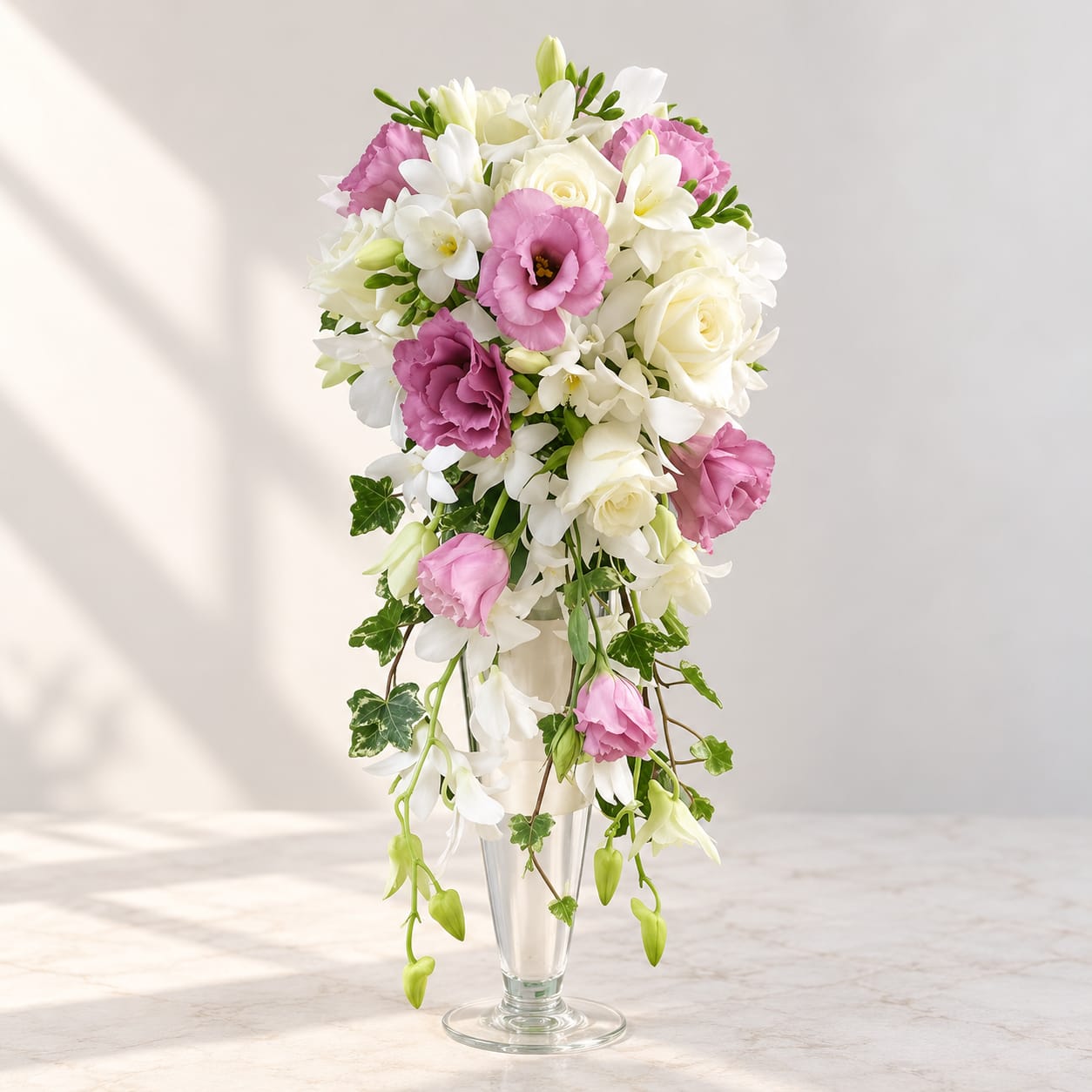 Pink and white bridal bouquet in a clear glass vase
