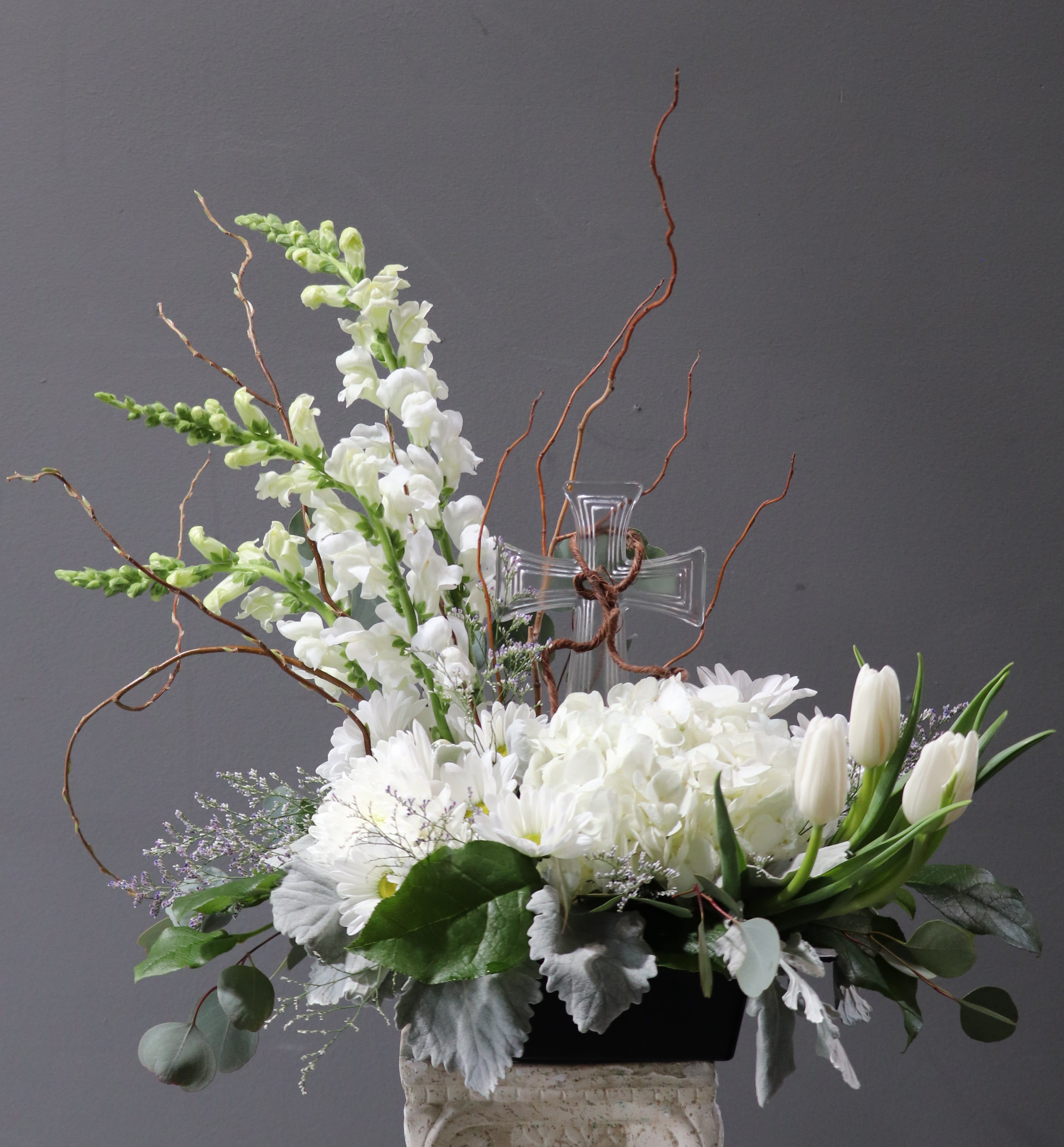 Faithful - An arrangement with a keepsake glass cross in the center with white flowers in remembrance of faith, hope and love!