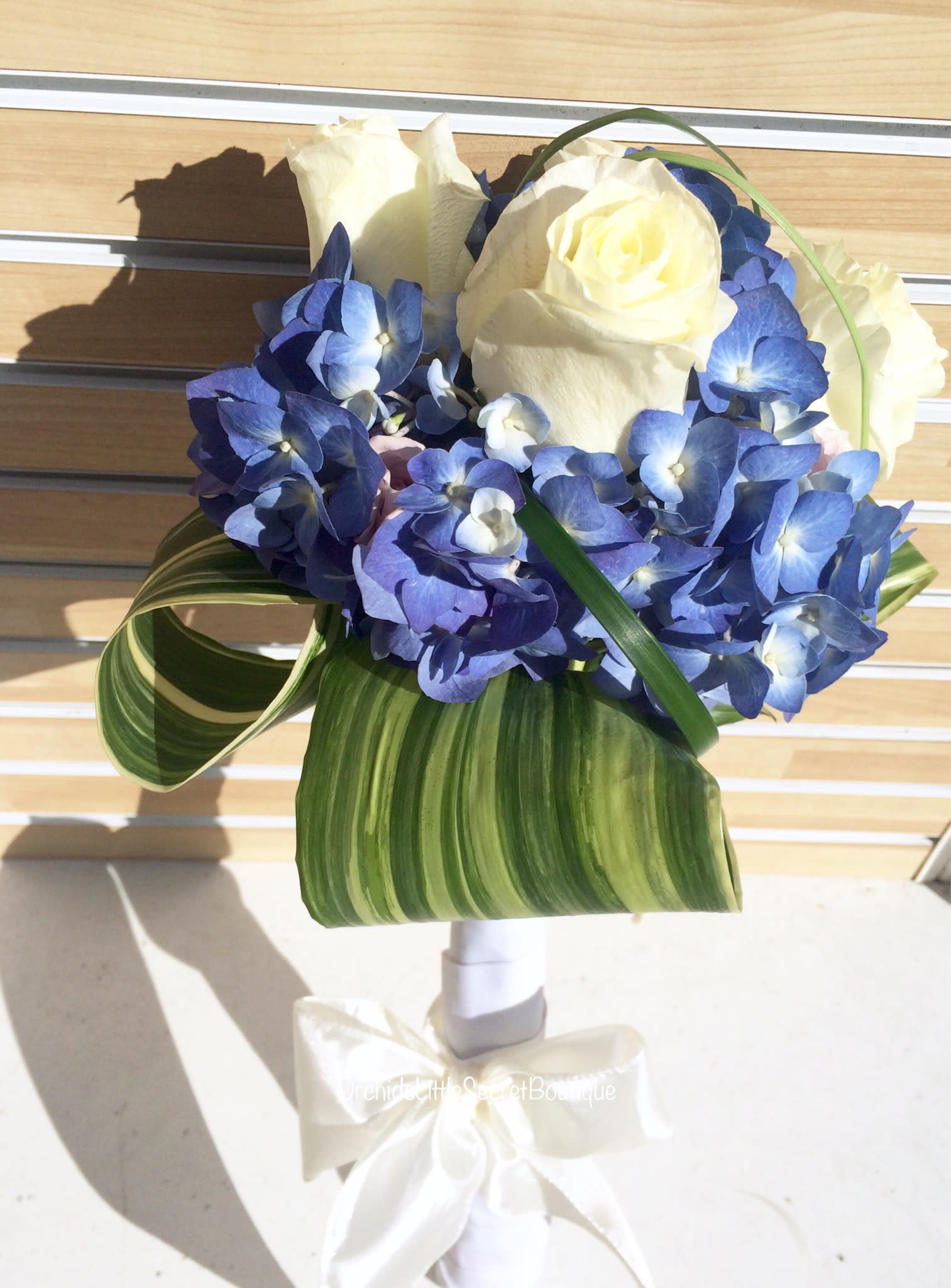 Blue hydrangea bouquet with white roses and striped leaves