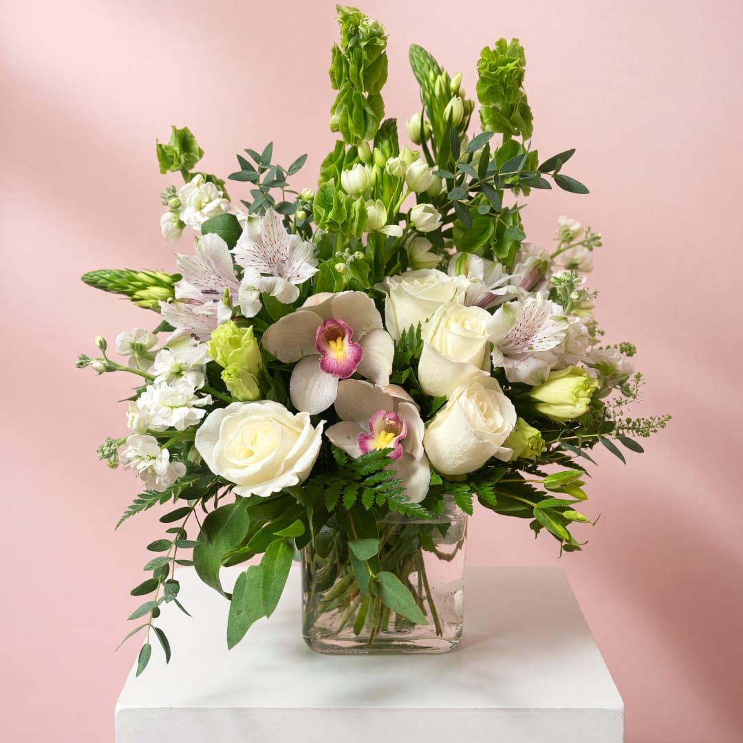 White and green floral arrangement in a clear glass vase