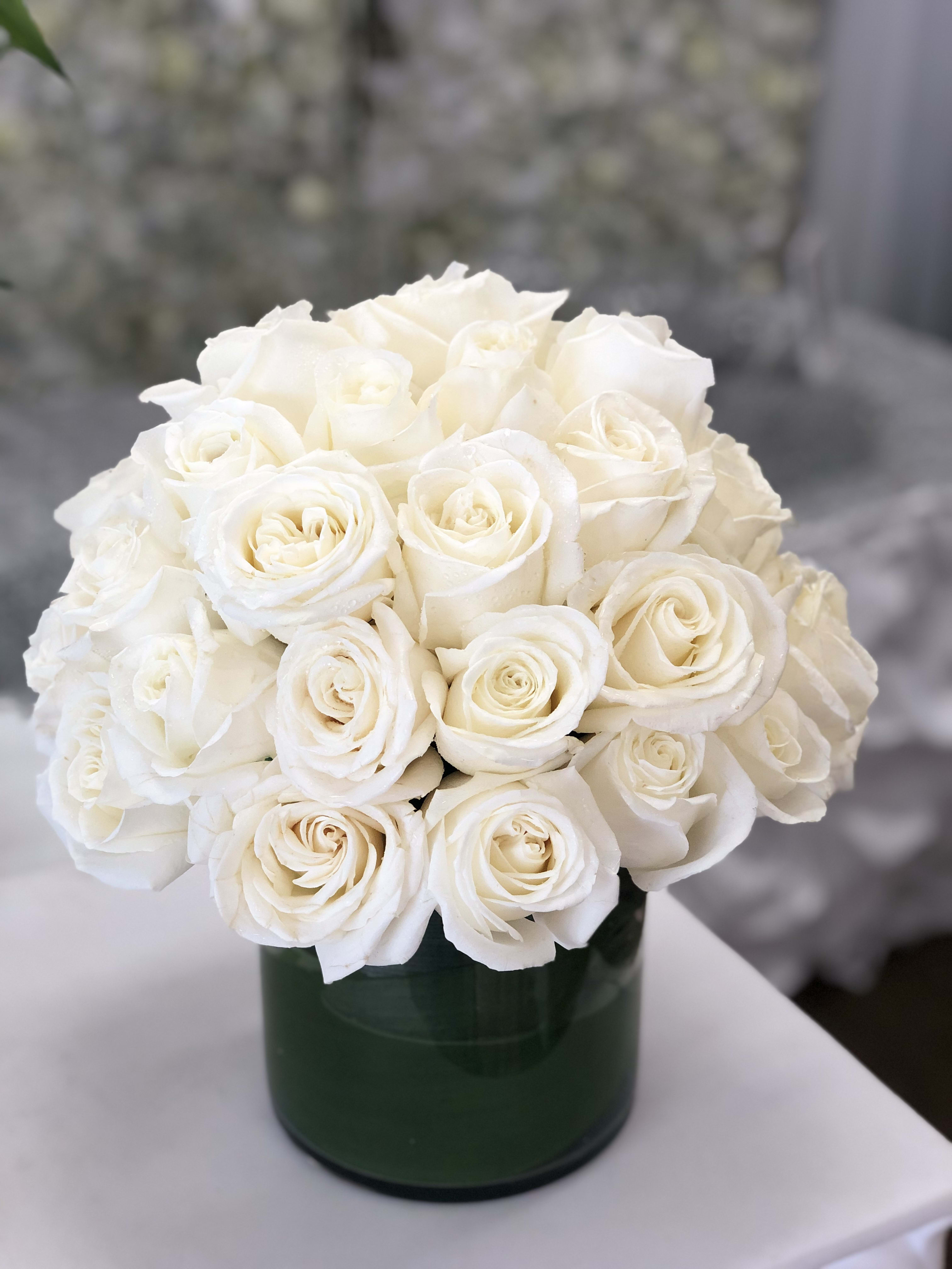 White rose bouquet in a dark green vase