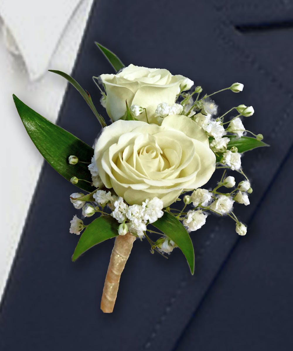 White rose boutonniere with baby's breath and green leaves