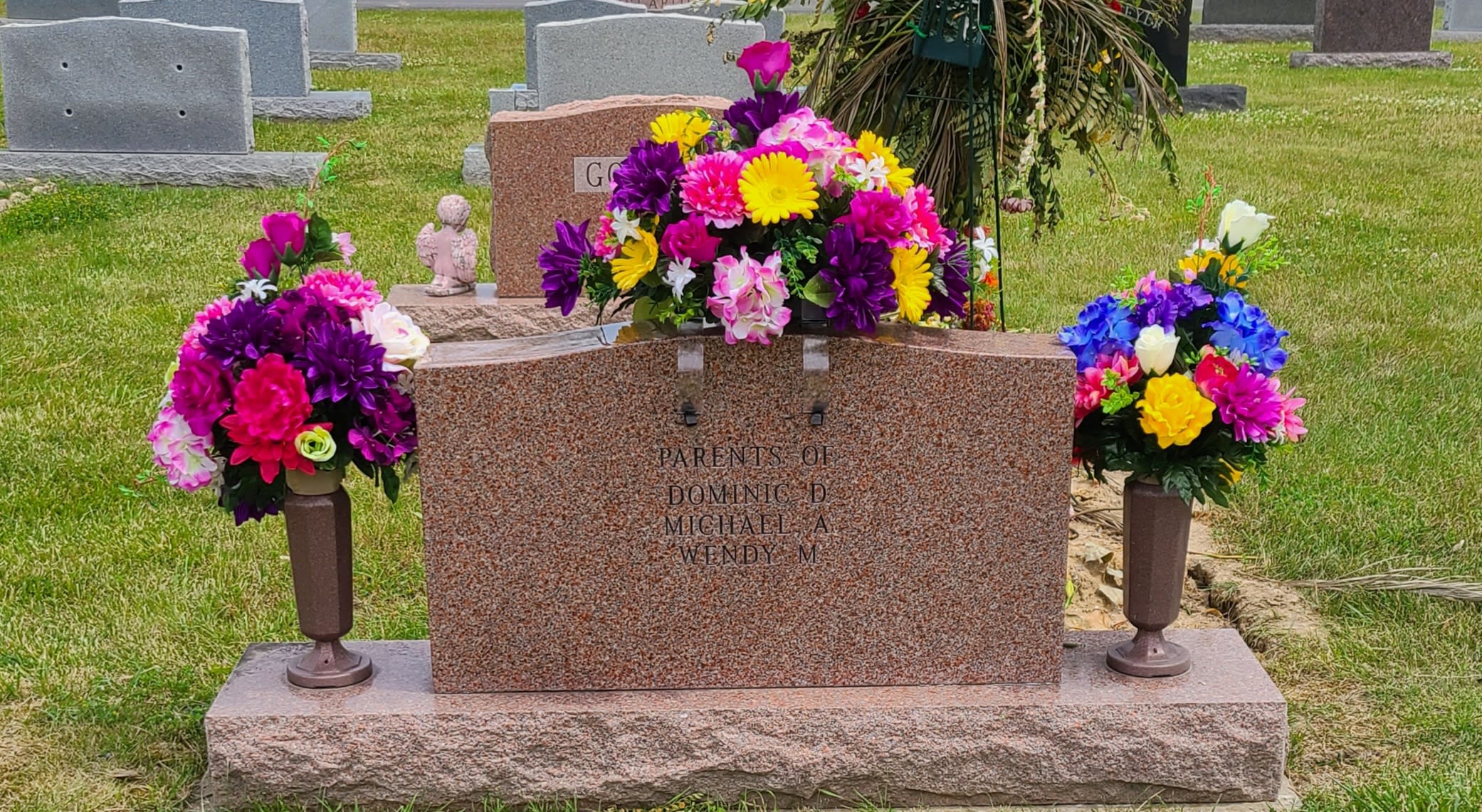 Colorful floral cemetery arrangement around a gravestone