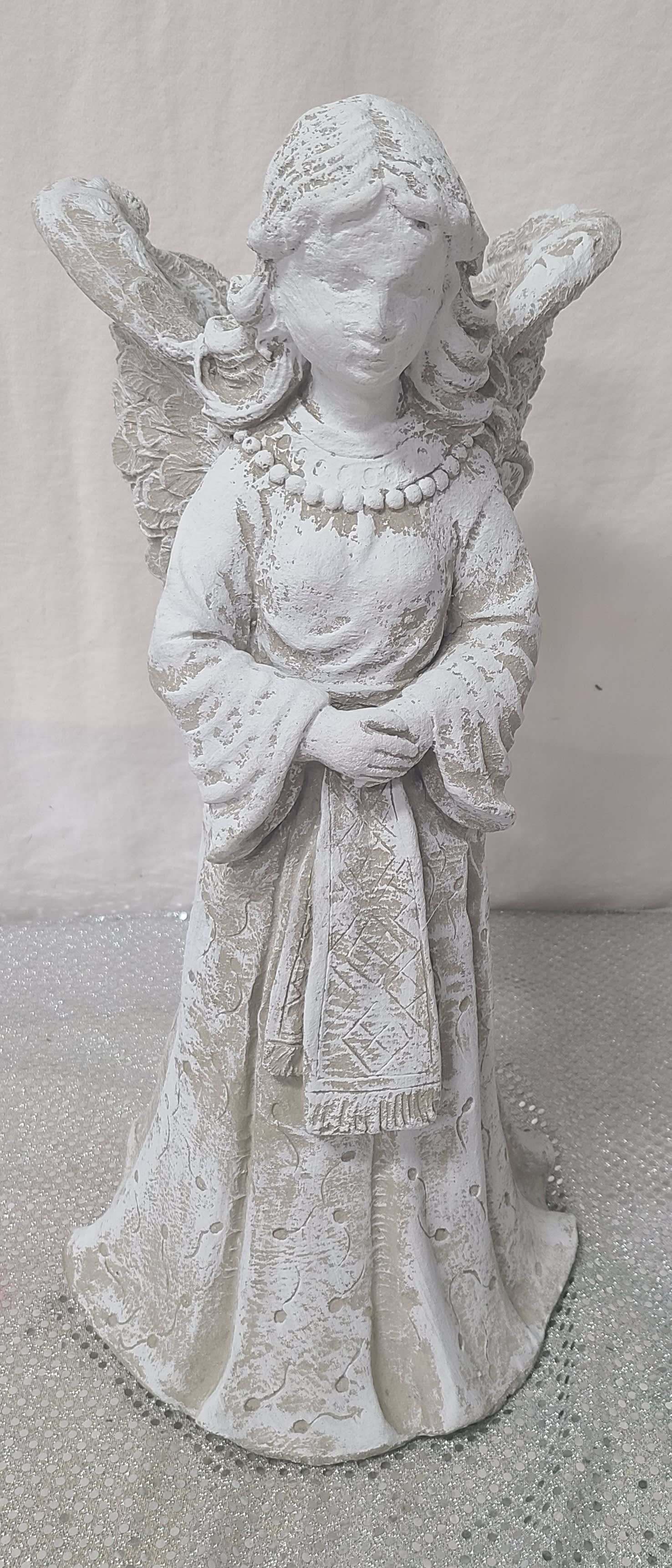 White angel figurine with wings and folded hands
