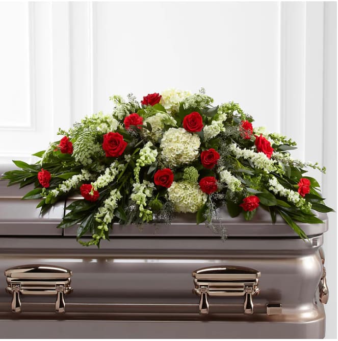 Red roses and white flowers arranged on a casket