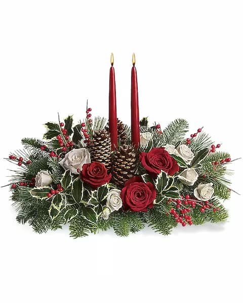 Holiday centerpiece with red candles, roses, and pinecones