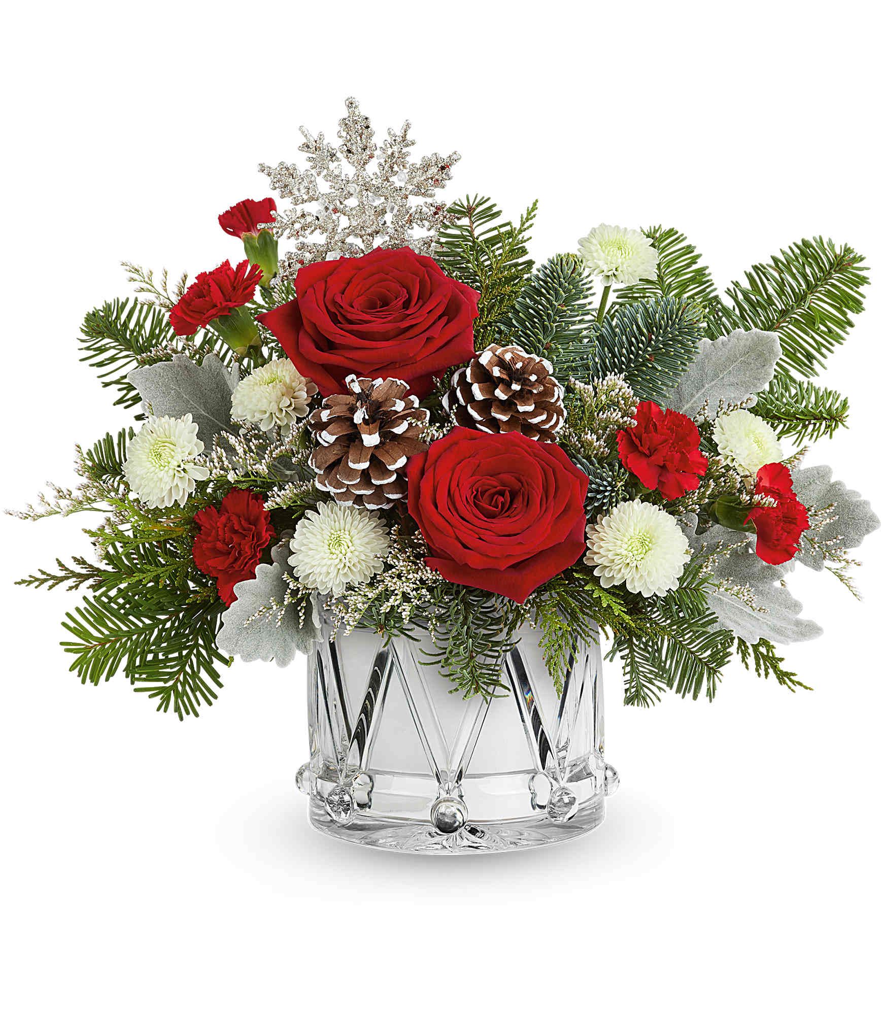 Red roses and white mums in a clear glass vase with pinecones