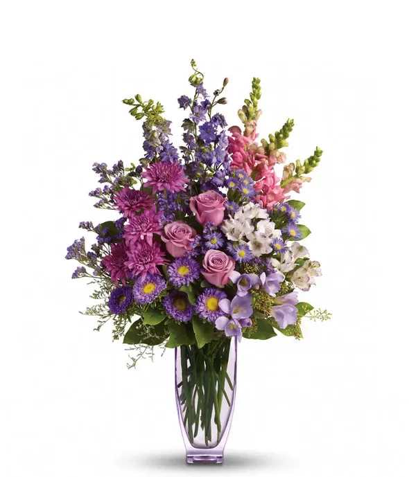 Purple and pink mixed bouquet in a tall glass vase