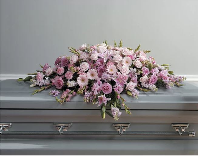 Pink floral casket spray with roses and lilies