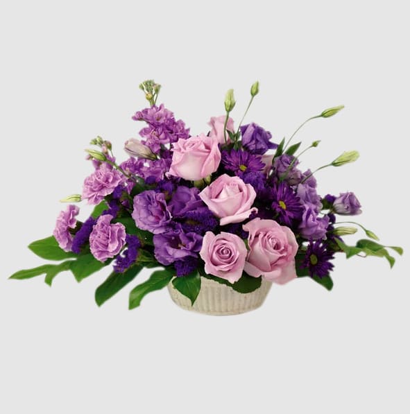 Pink and purple roses arranged in a low basket