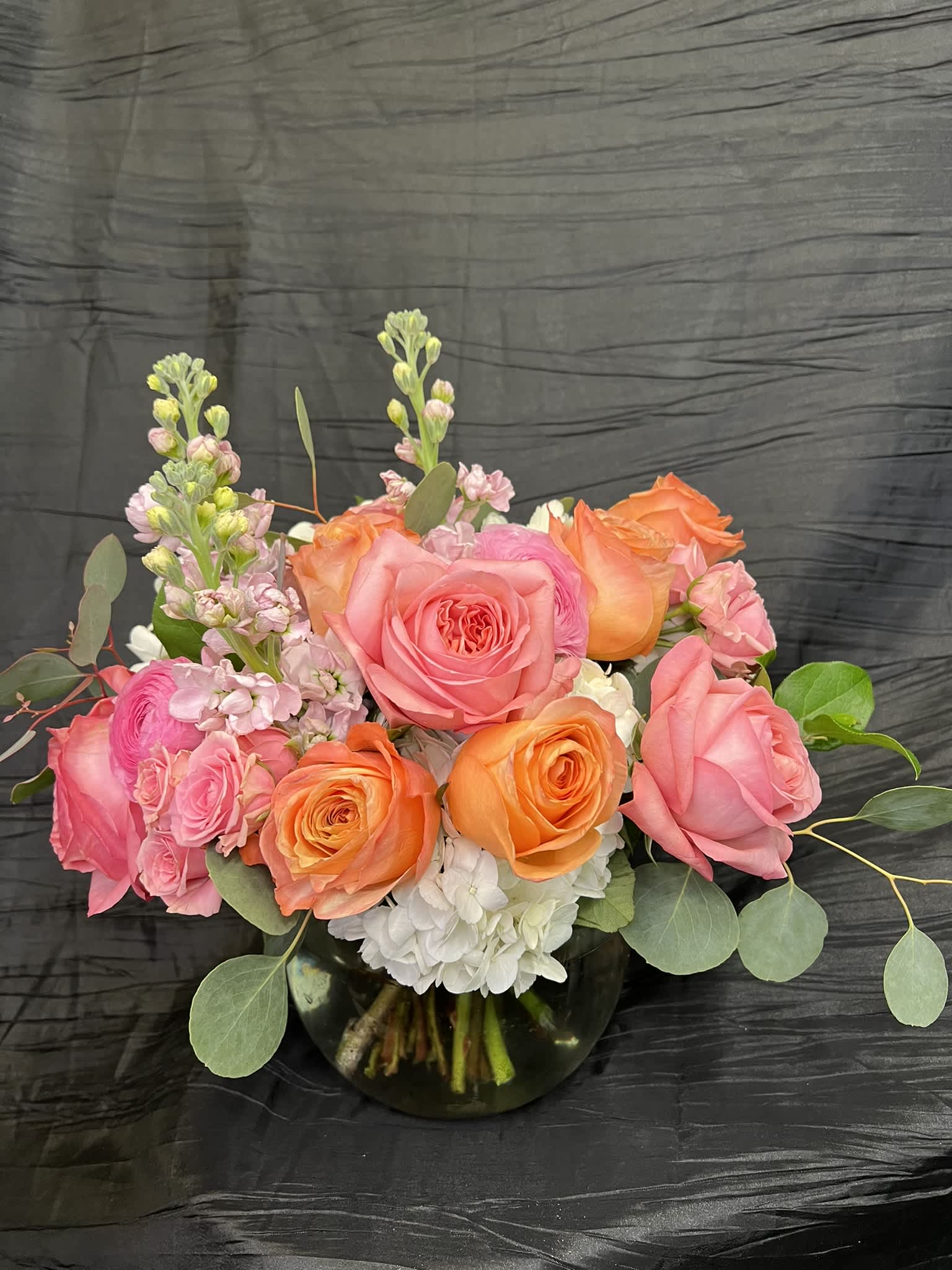Pink and orange rose bouquet in a glass vase