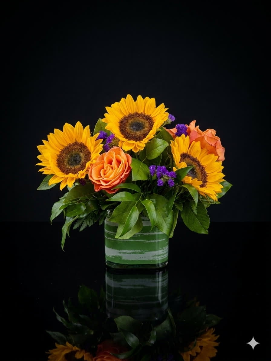 Sunflowers and orange roses arranged in a glass vase