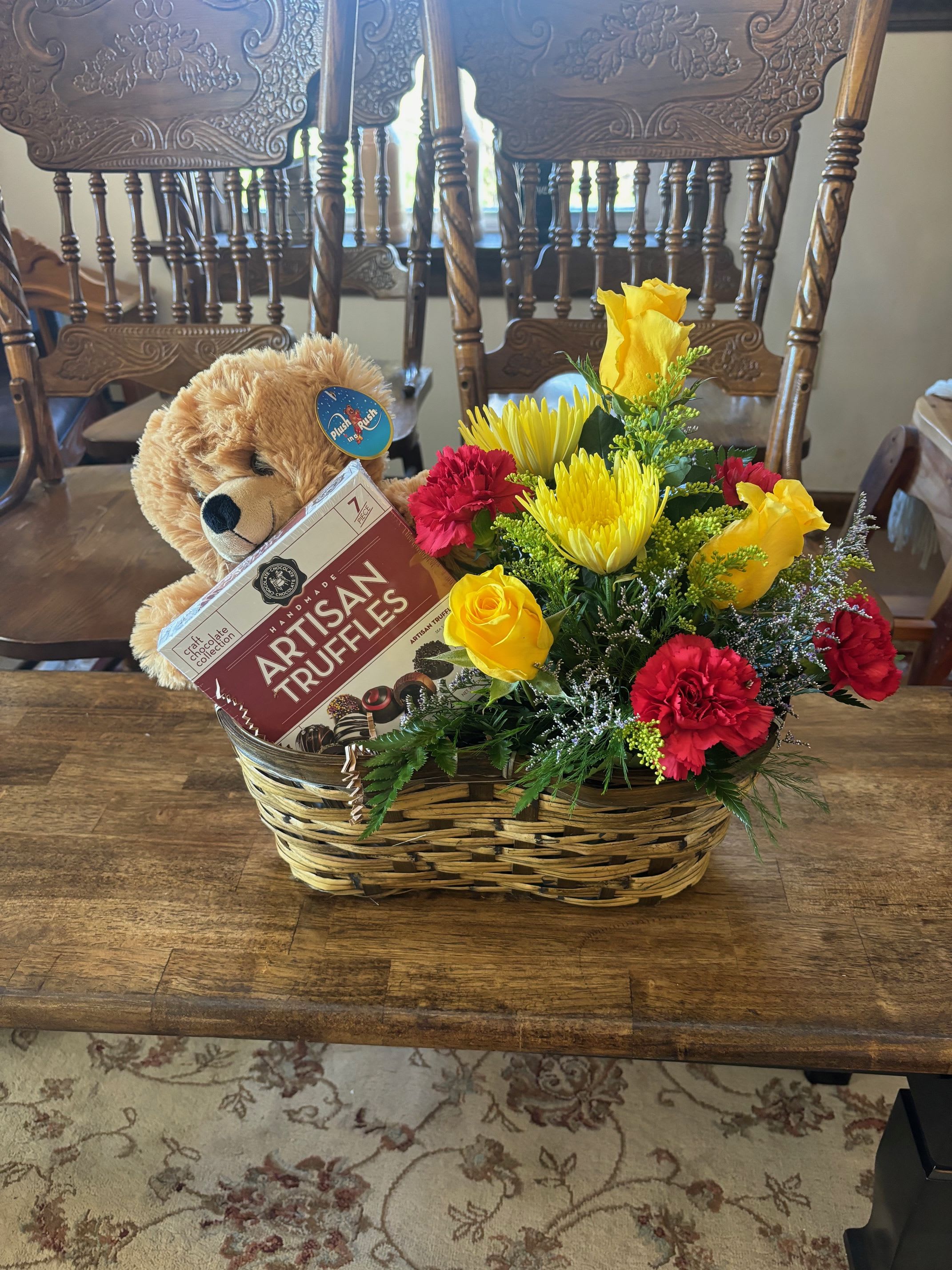 Gift basket with flowers, teddy bear, and chocolate truffles