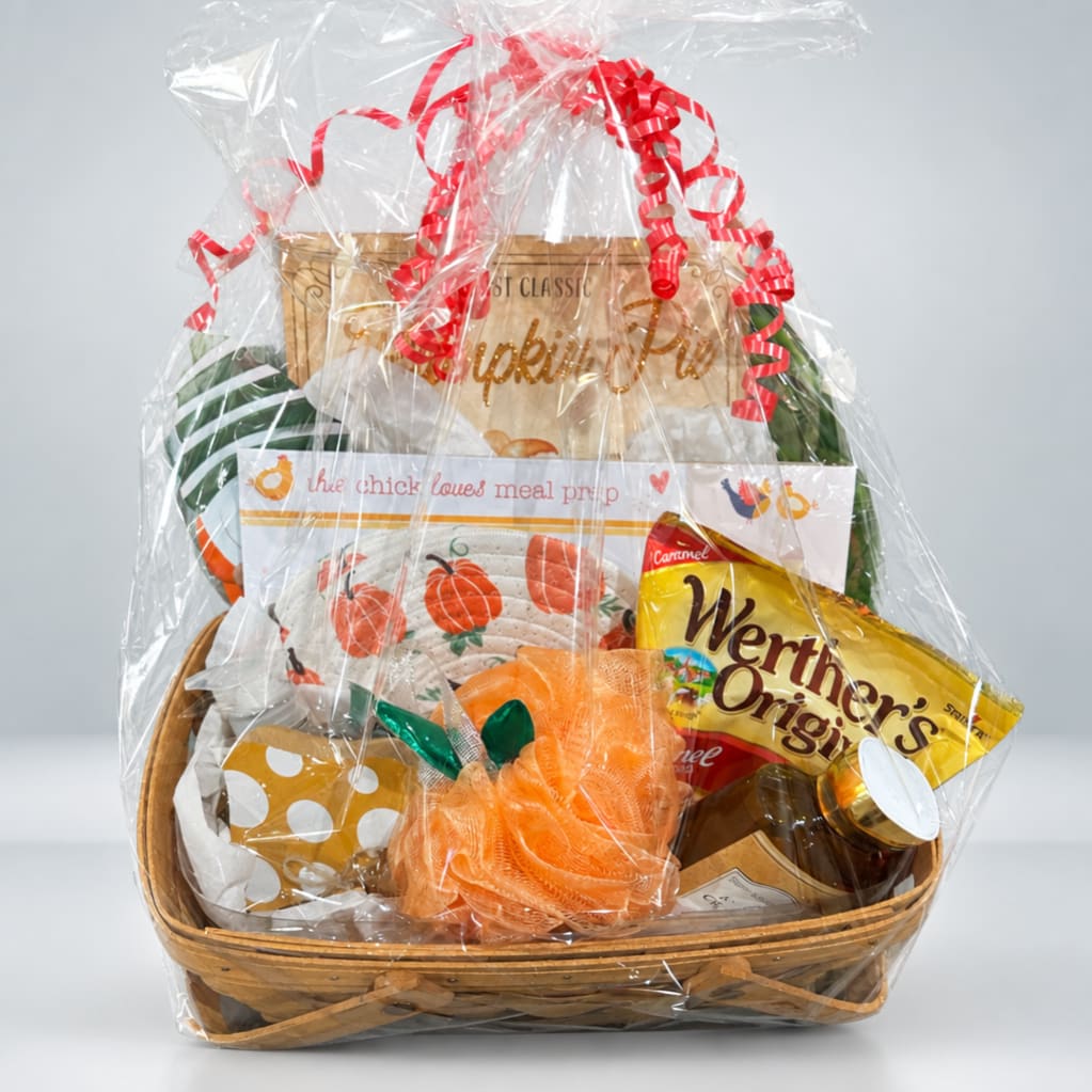 Gift basket with kitchen items and snacks wrapped in clear cellophane