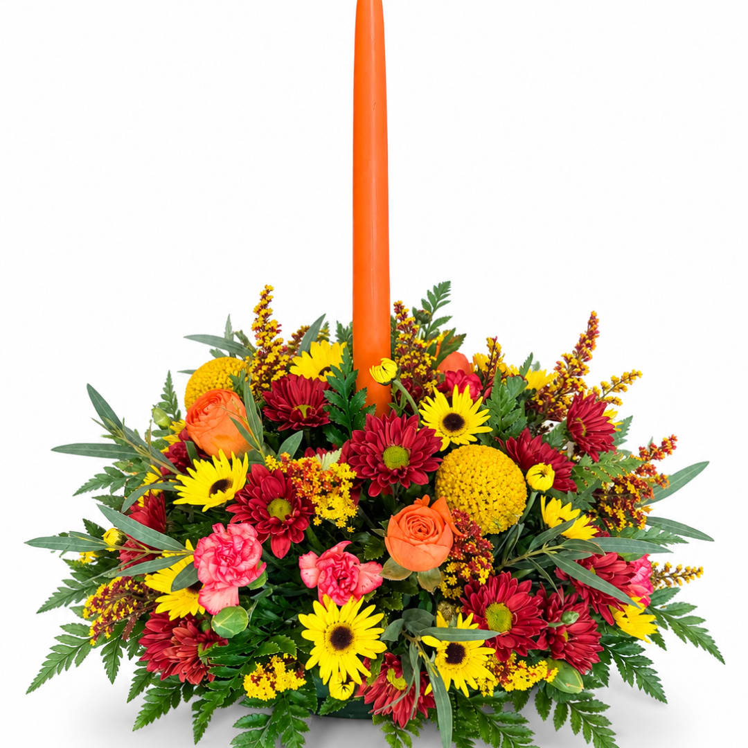 Colorful floral centerpiece with a tall orange candle in the middle
