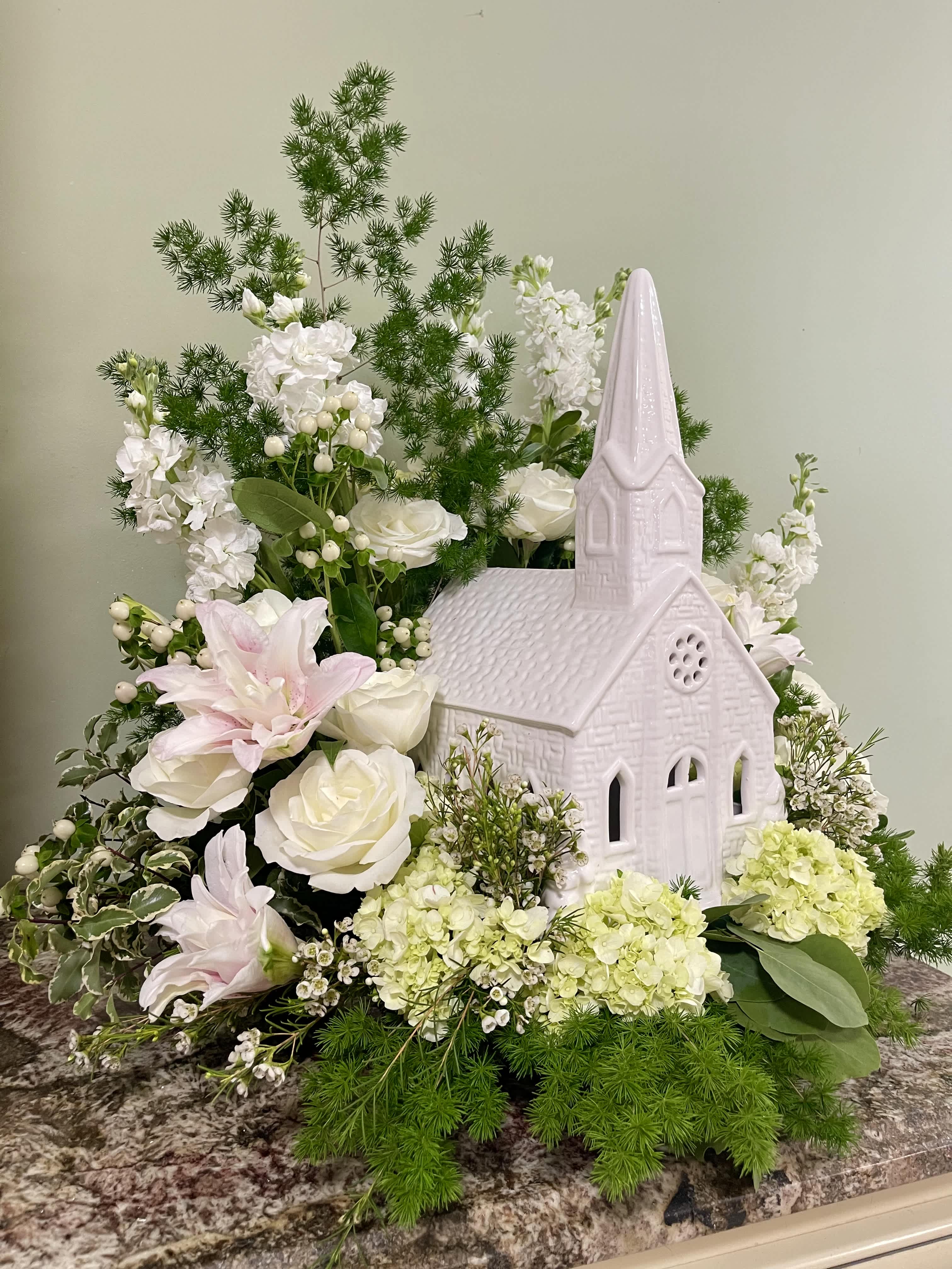 White floral arrangement with a pink church centerpiece