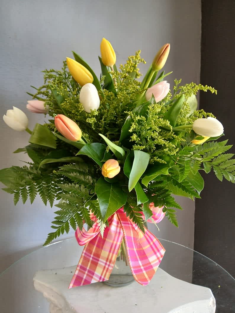 Mixed tulip bouquet in a glass vase with a pink plaid ribbon