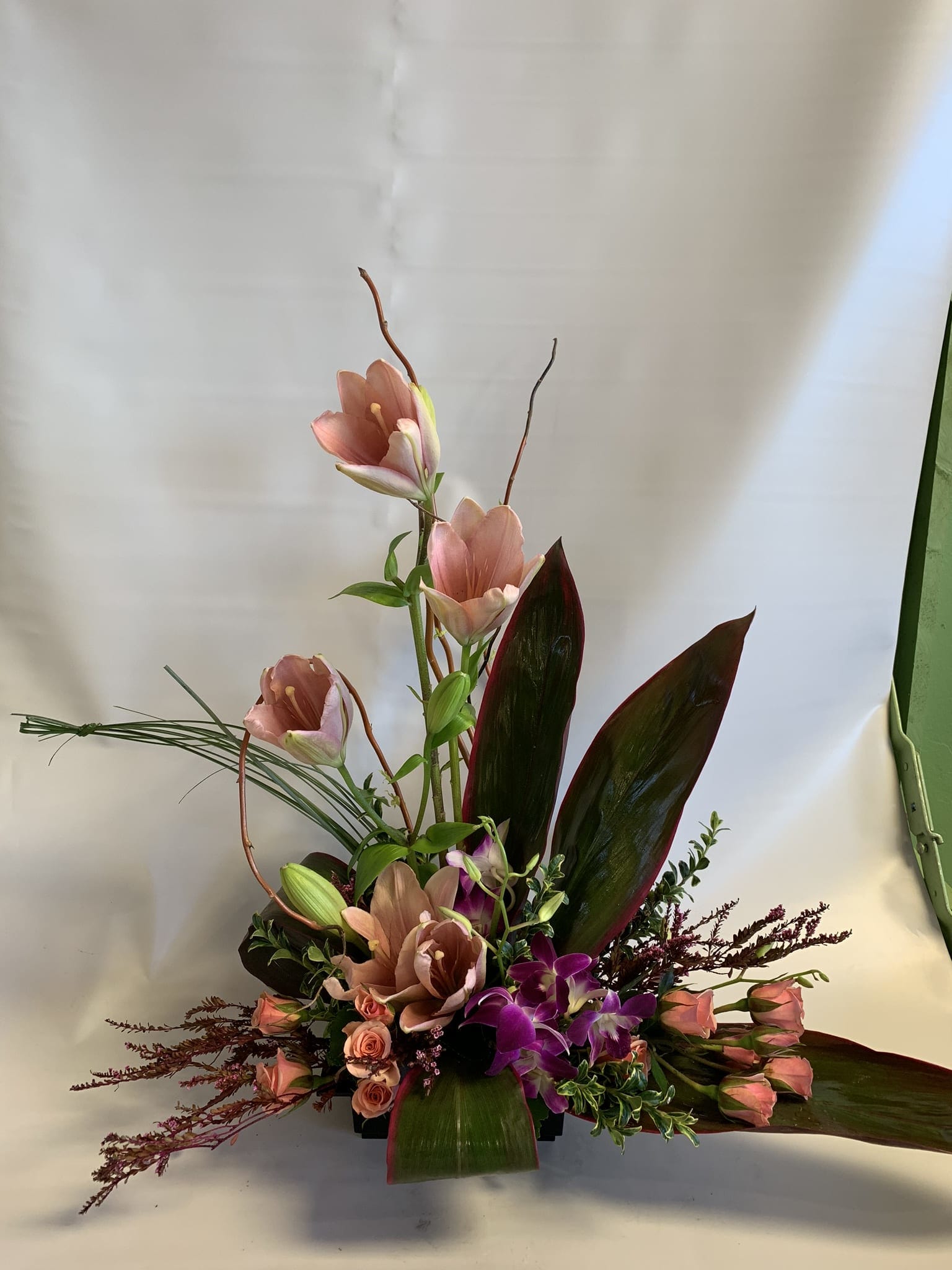 Tall floral arrangement with pink blooms and purple orchids