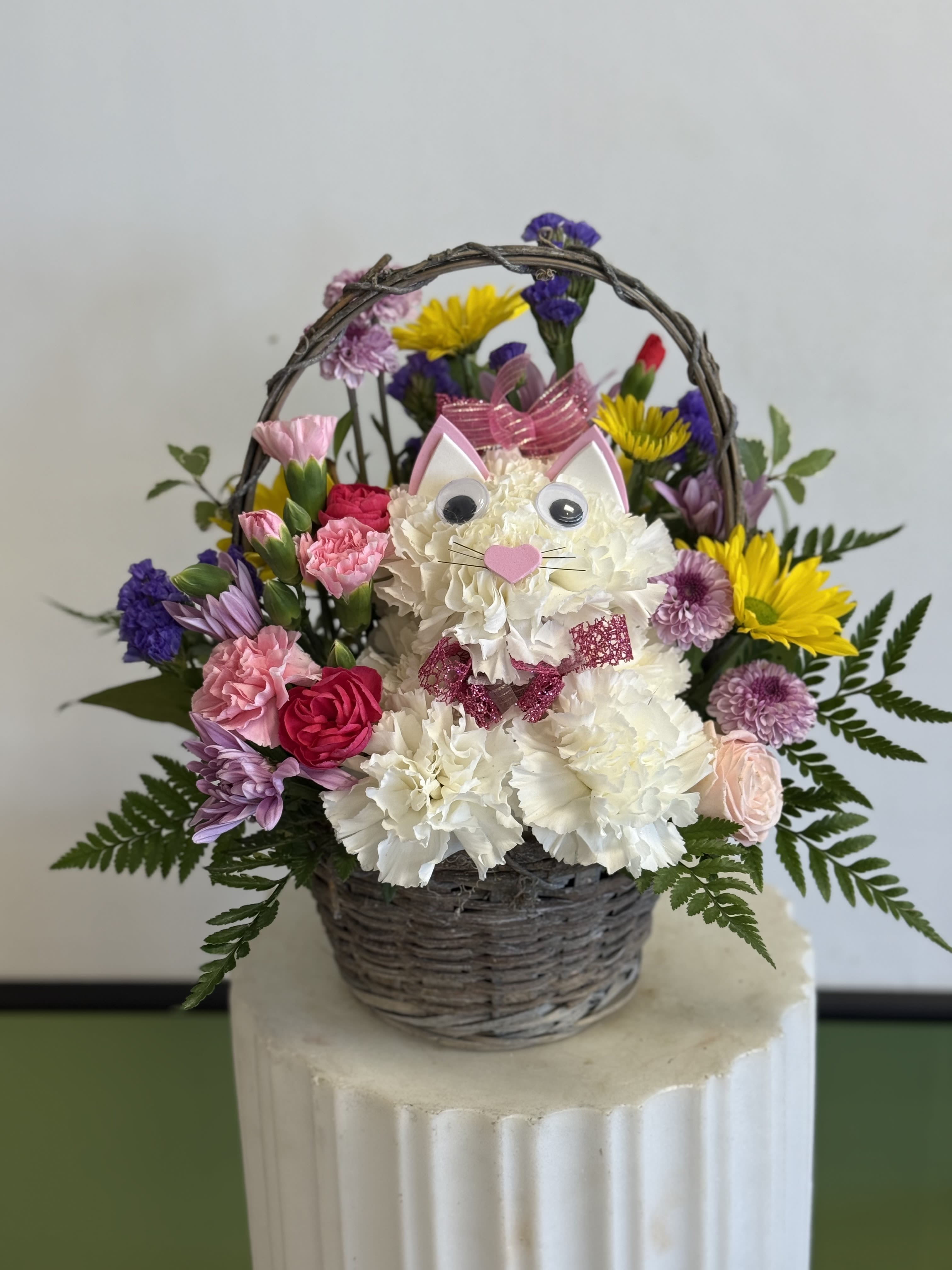 Basket arrangement with a cat face made of white flowers and colorful blooms