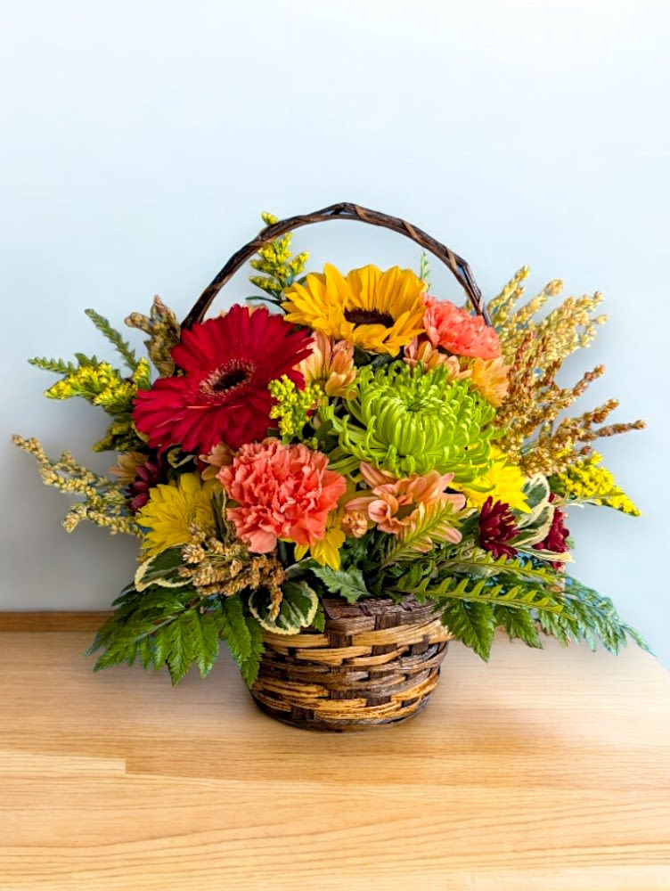 Fall Fiesta Basket - Add a pop of color to your fall décor with our Fall Fiesta! Featuring a vibrant mix of seasonal flowers in rich autumn hues, this playful arrangement is perfect for bringing warmth and joy to any room. Whether you're celebrating the season or looking for the perfect fall gift, this fresh, cheerful basket will brighten any space with its festive fall spirit.  Flowers may vary, but we will use our best blooms in a bright mix of fall colors in the style pictured. 