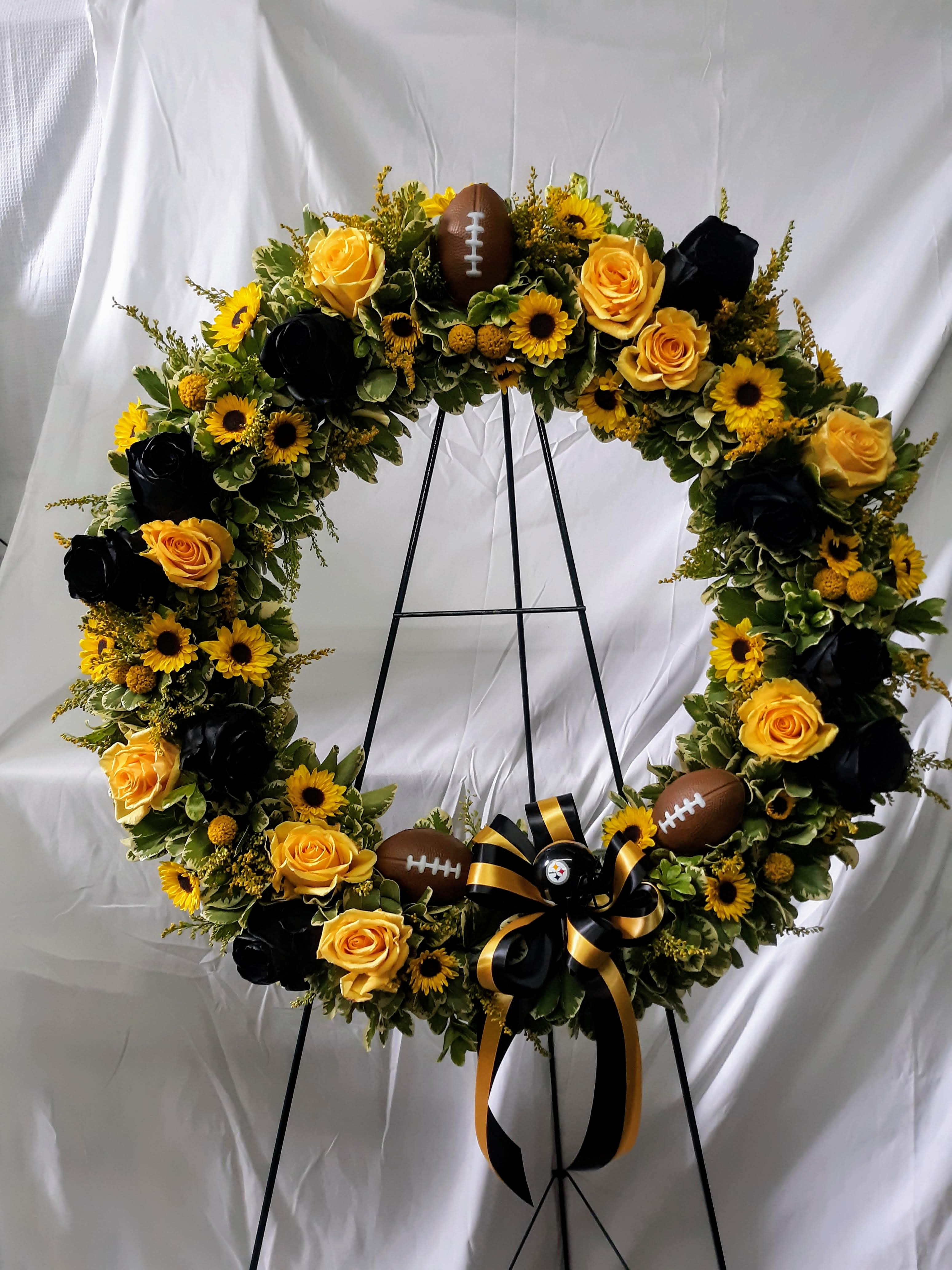 Football-themed floral wreath with yellow roses and sunflowers