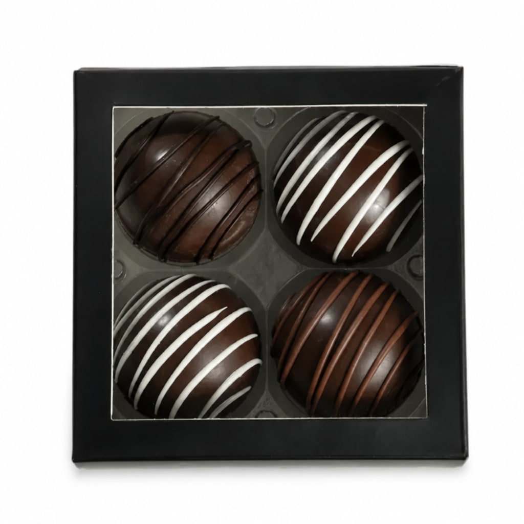 Box of four chocolate truffles with striped drizzle