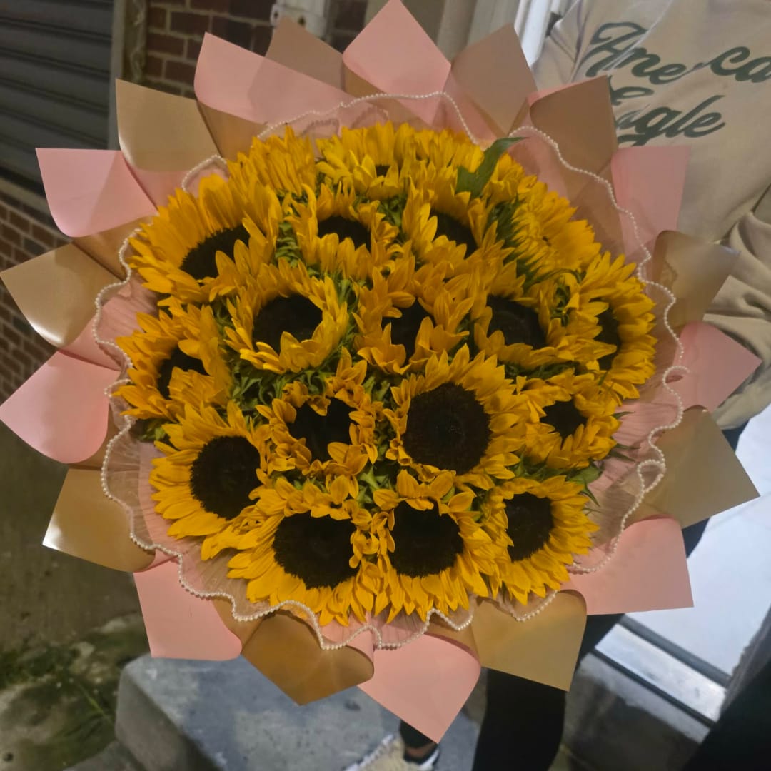 Bouquet of yellow sunflowers wrapped in pink and tan paper