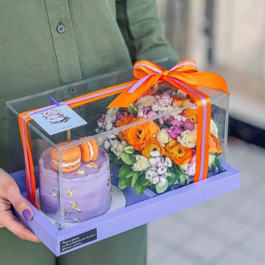 Gift box with flowers and macarons under a clear cover
