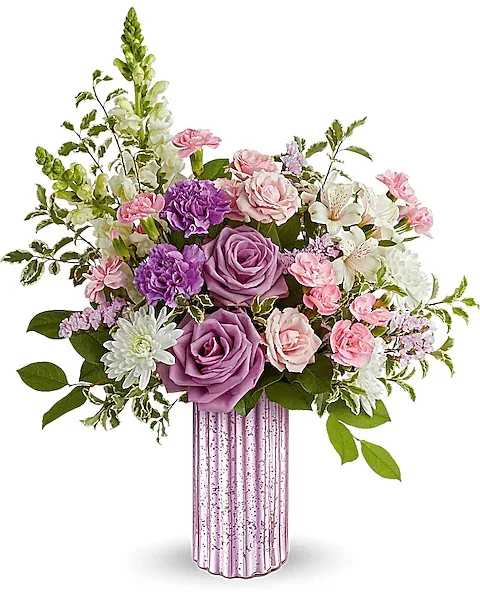 Pink and purple floral arrangement in a ribbed glass vase