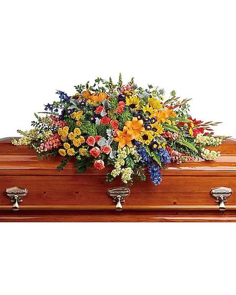 Colorful floral casket spray on a wooden coffin