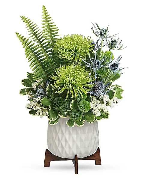Green chrysanthemum arrangement in a white vase with blue thistle accents