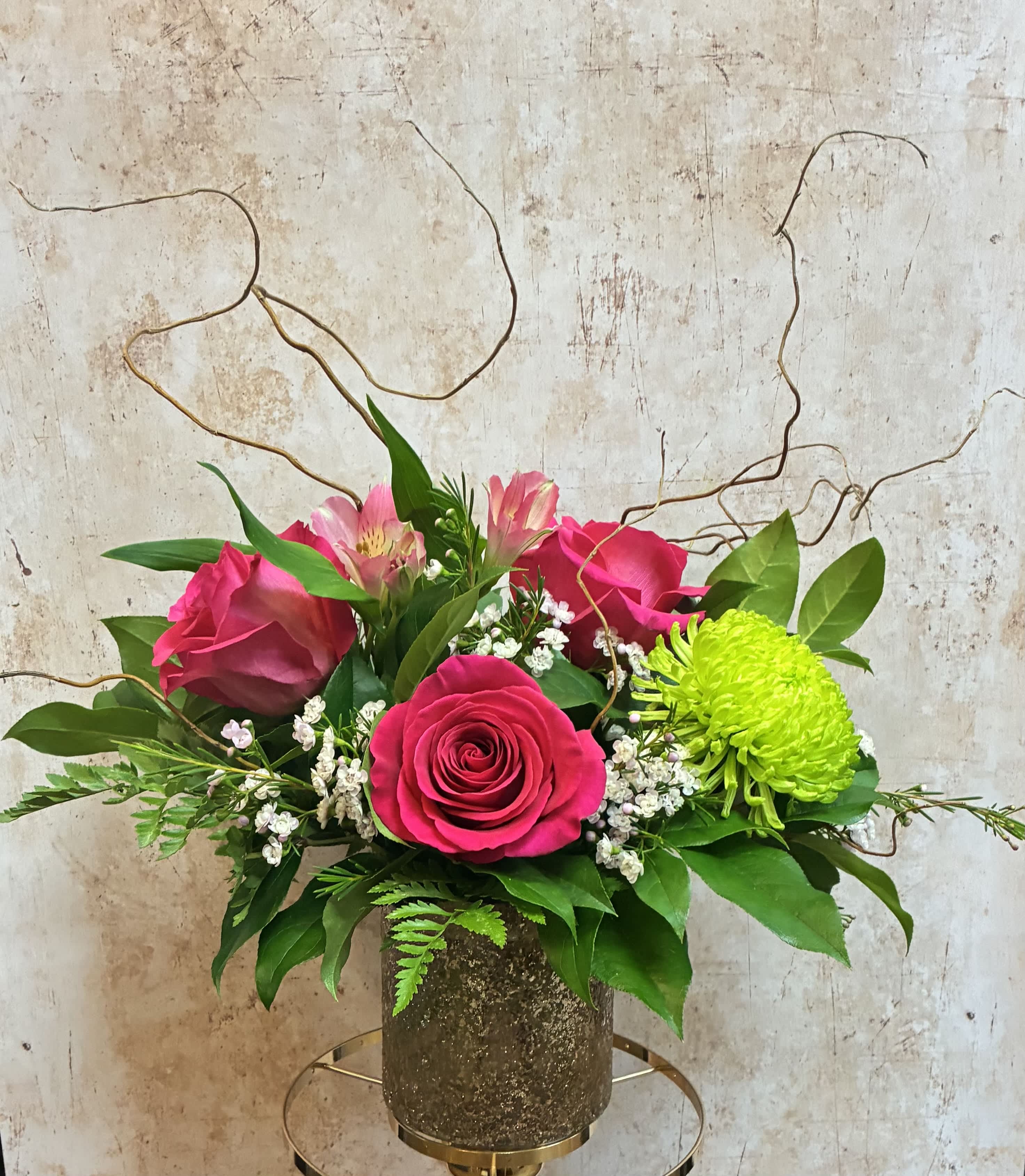 Pink roses and alstroemeria in a textured vase with bright green chrysanthemum