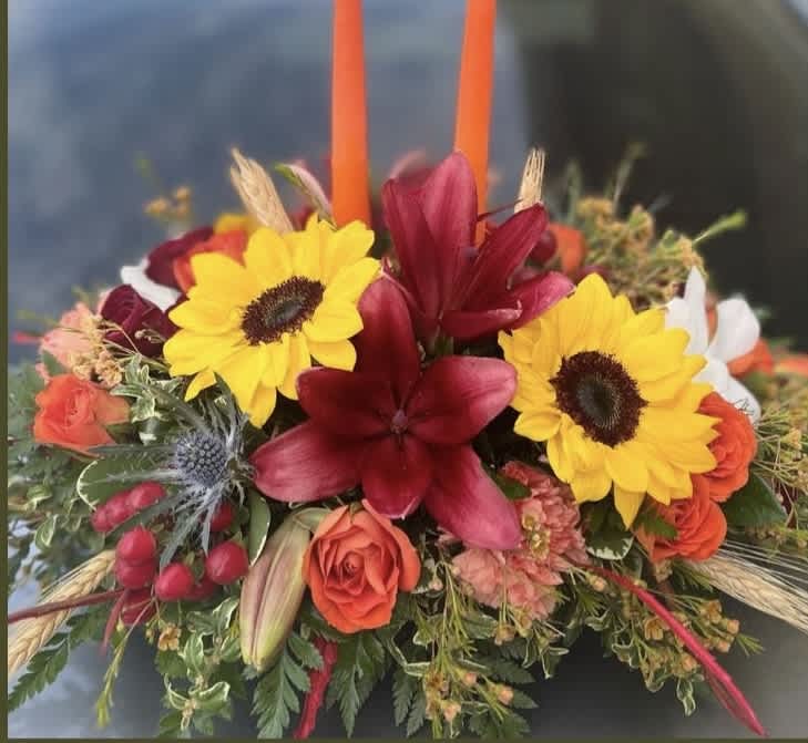 Colorful floral arrangement with sunflowers, red lilies, and orange roses
