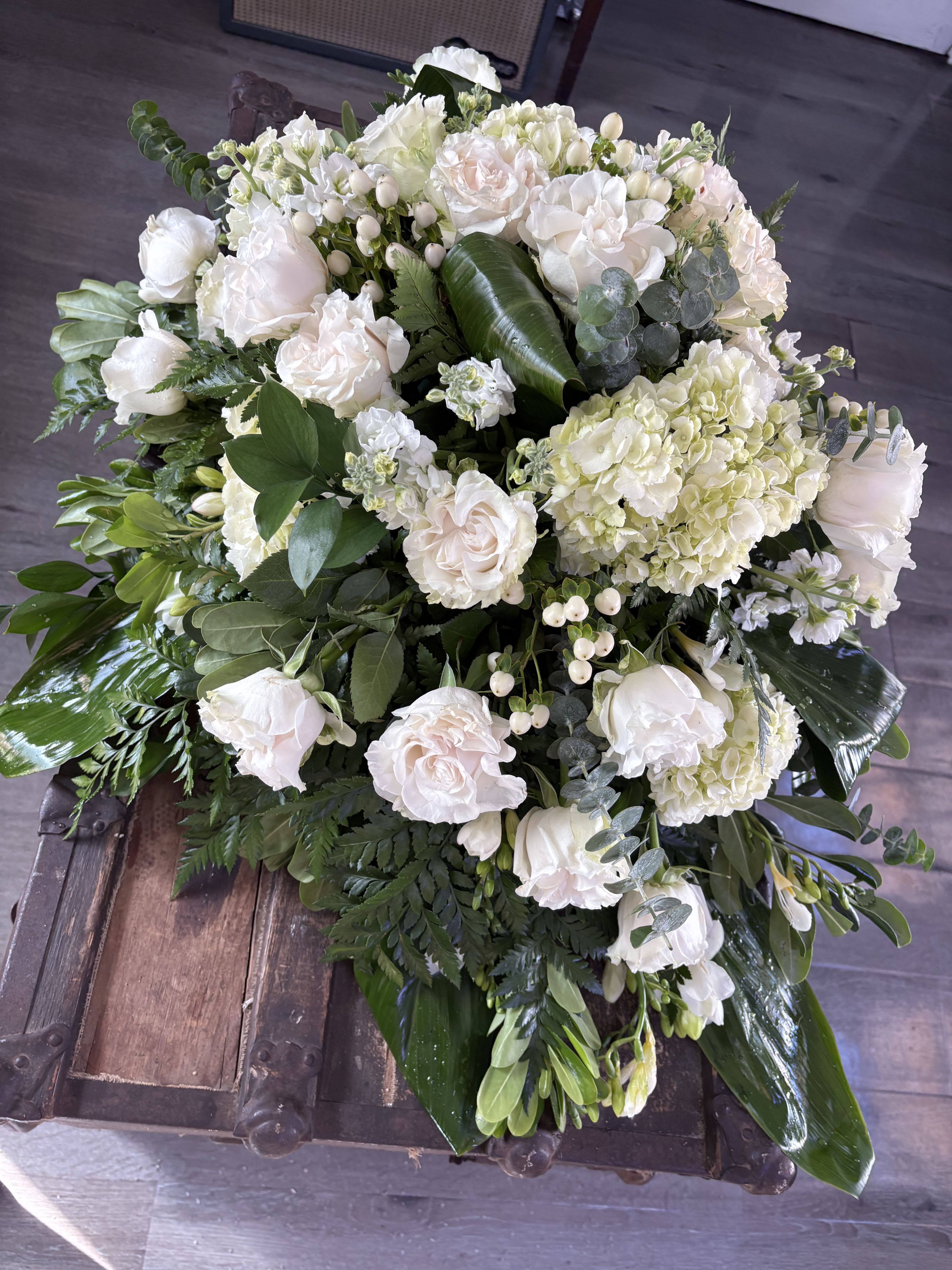 Large white floral arrangement with roses and hydrangeas
