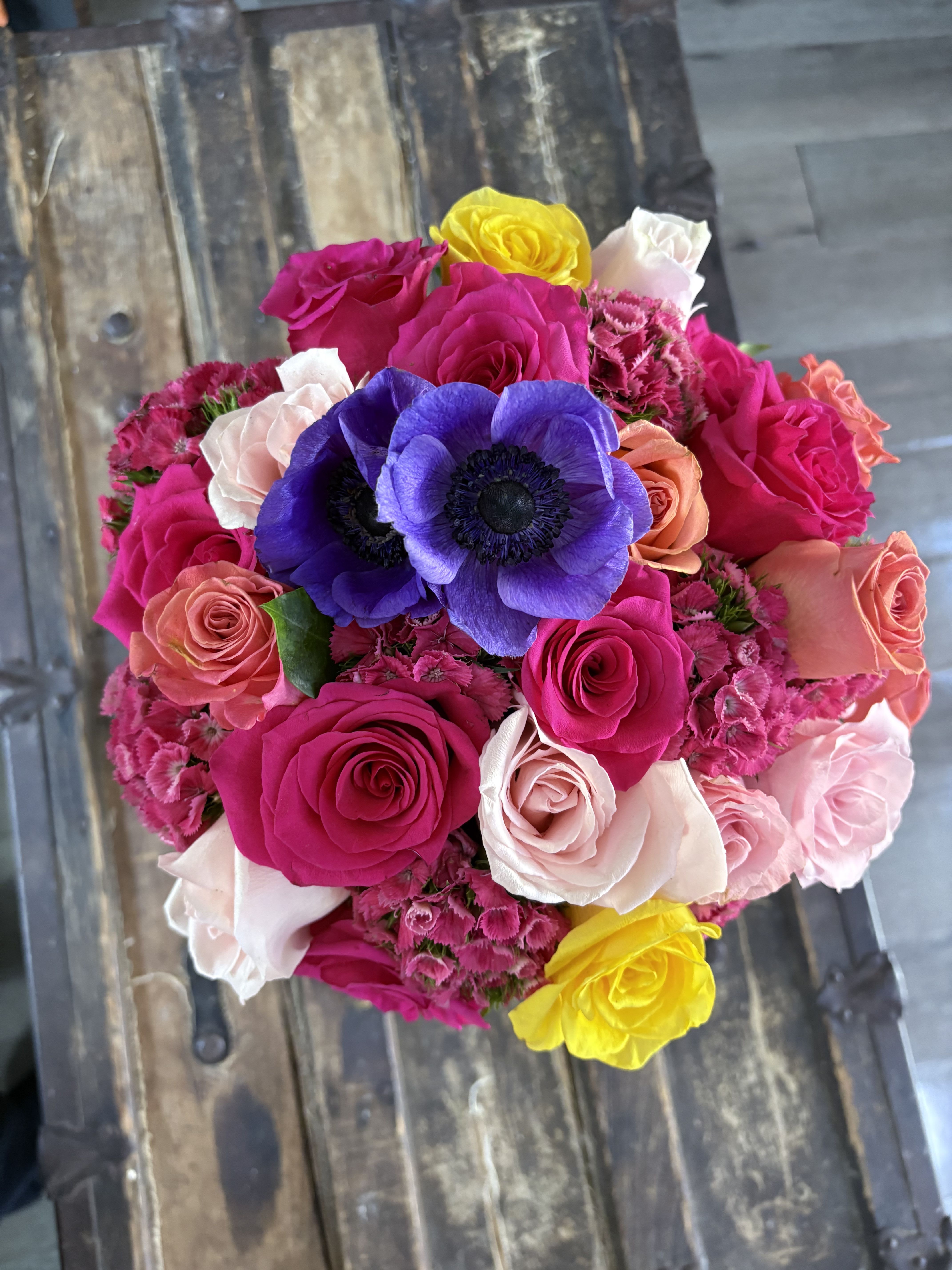Bright mixed bouquet of roses and purple anemones