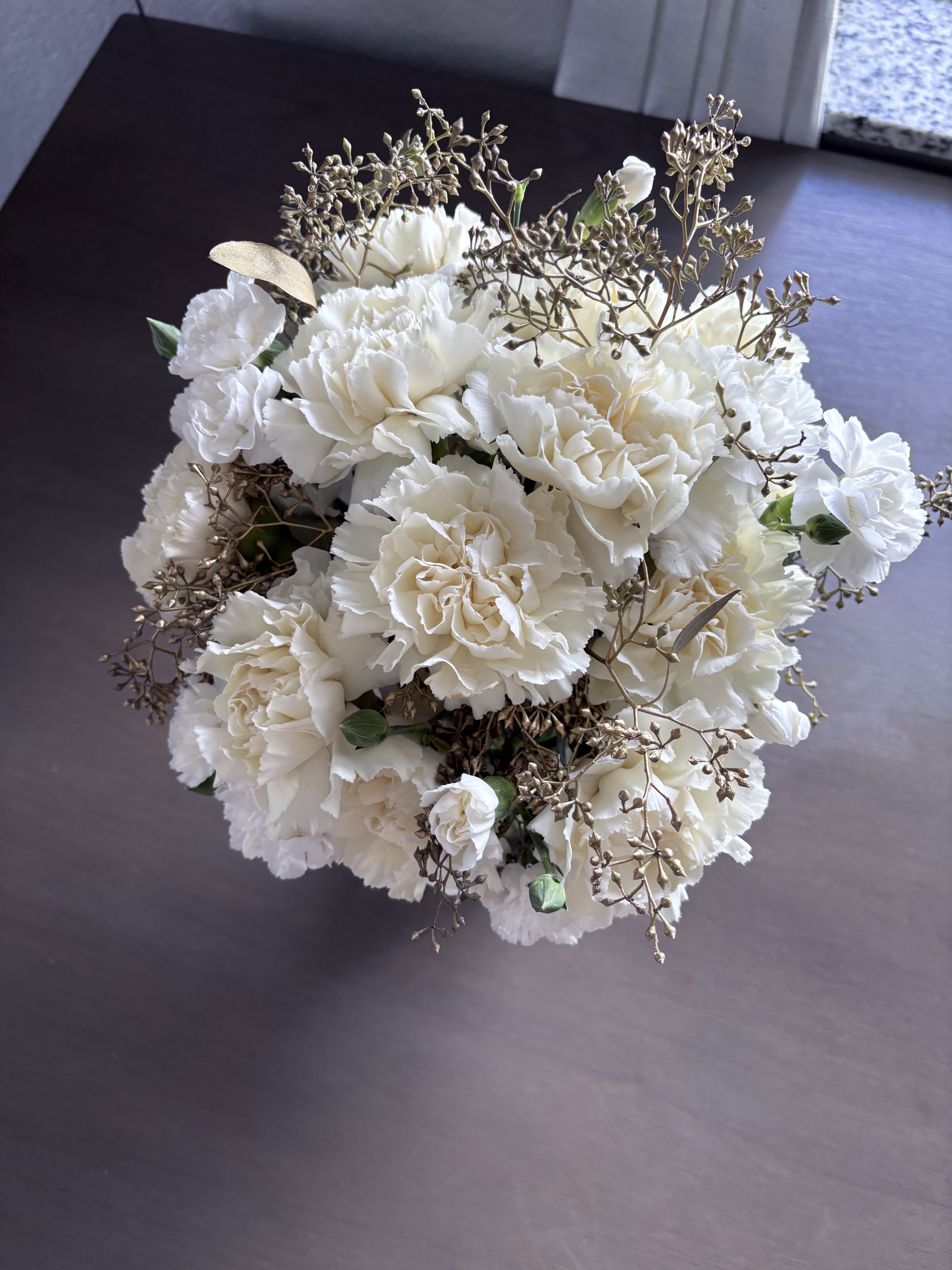 White carnation bouquet with delicate bronze filler