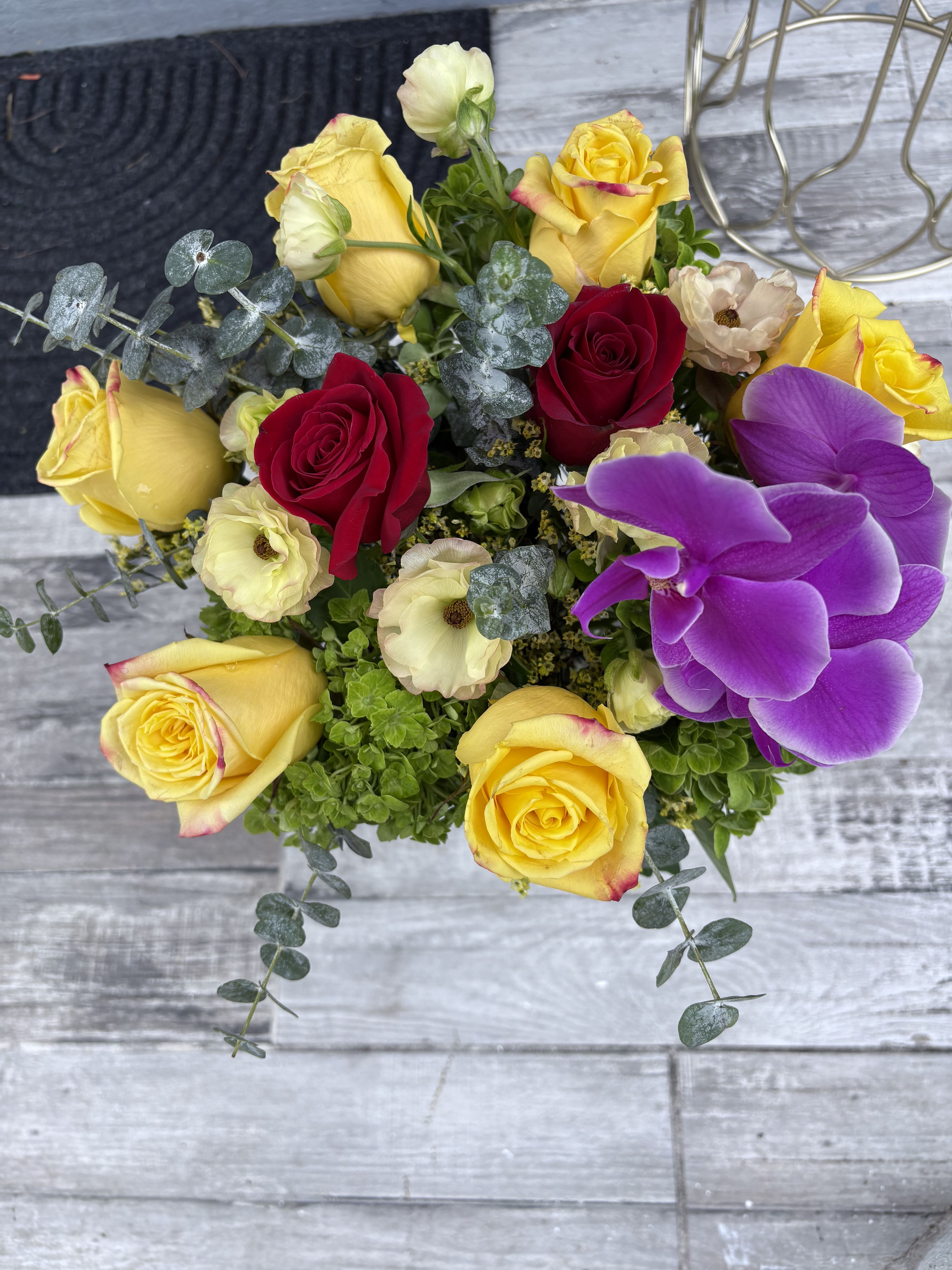 Bouquet of yellow and red roses with purple orchids
