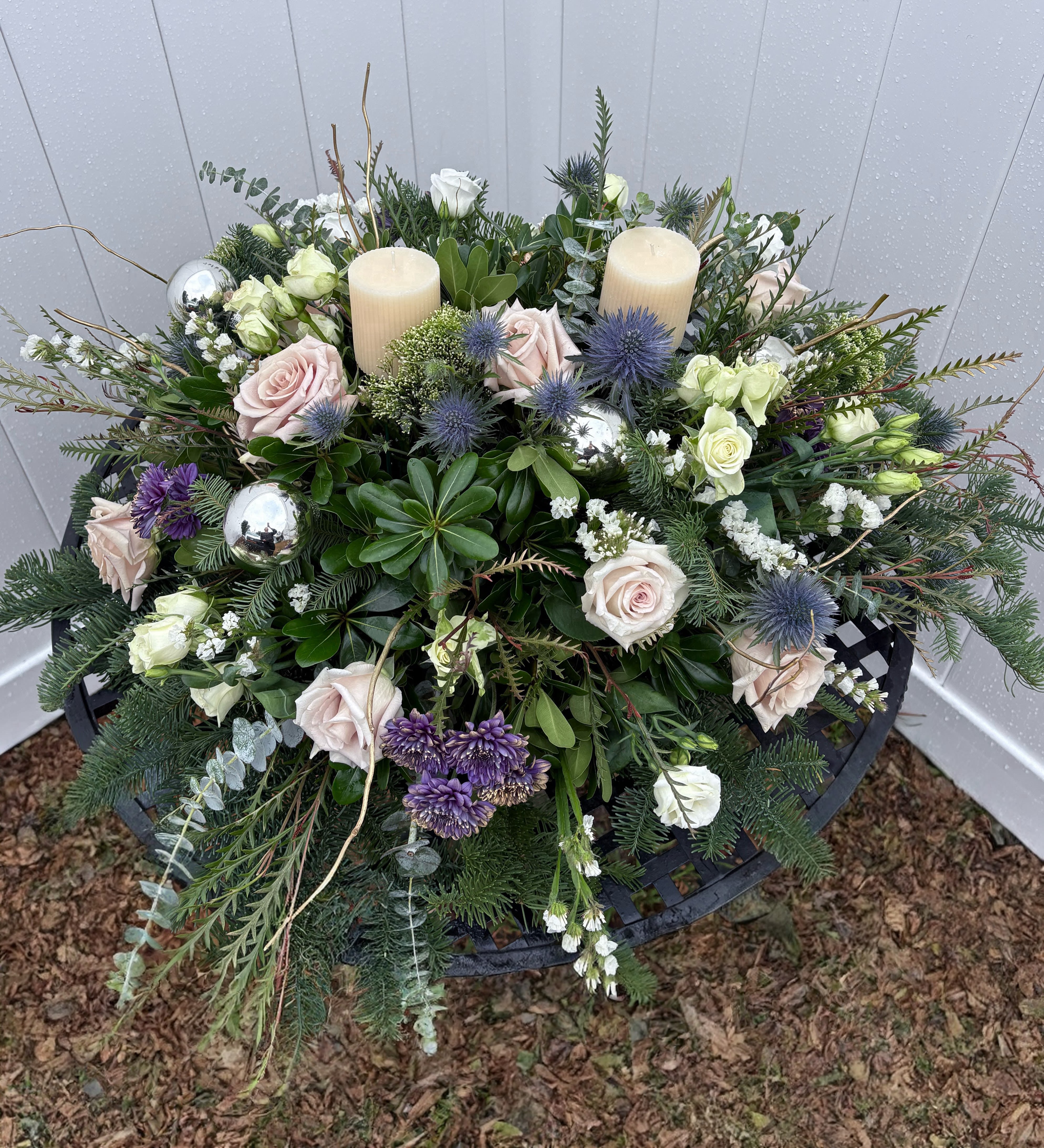 Floral wreath with roses, thistles, and candles