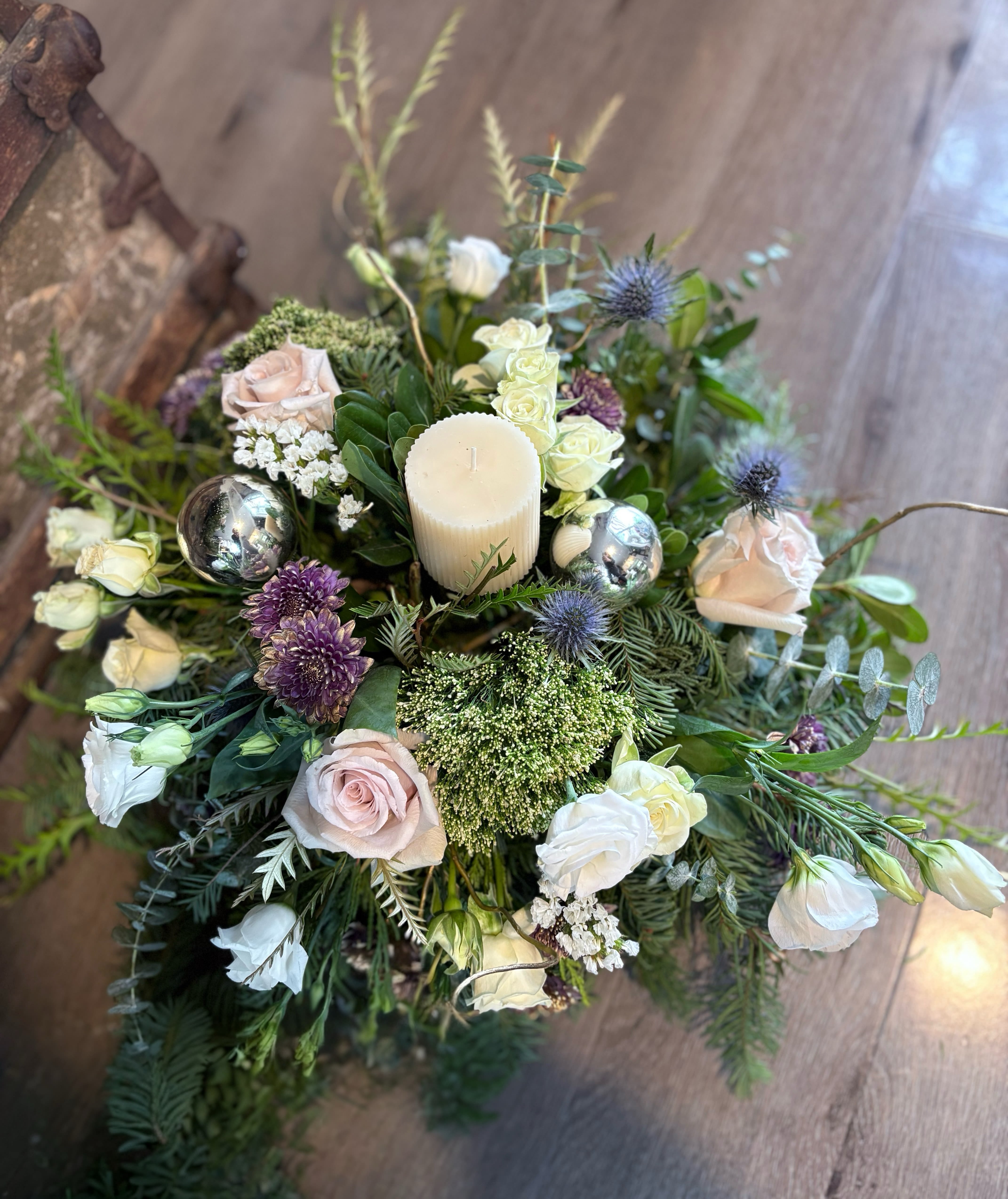 Floral centerpiece with roses, lisianthus, and a candle