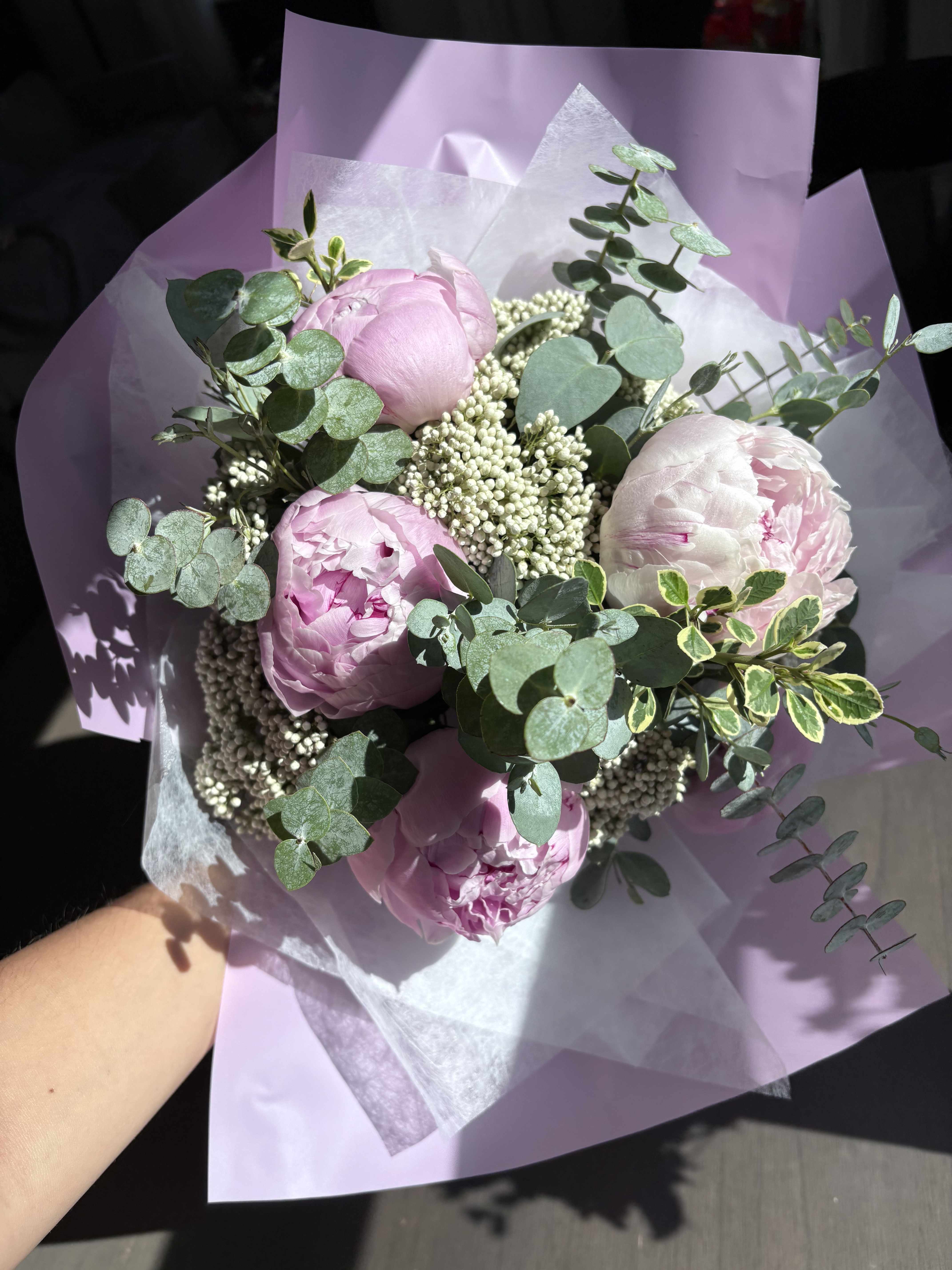 Pink peonies with eucalyptus in lavender wrapping paper