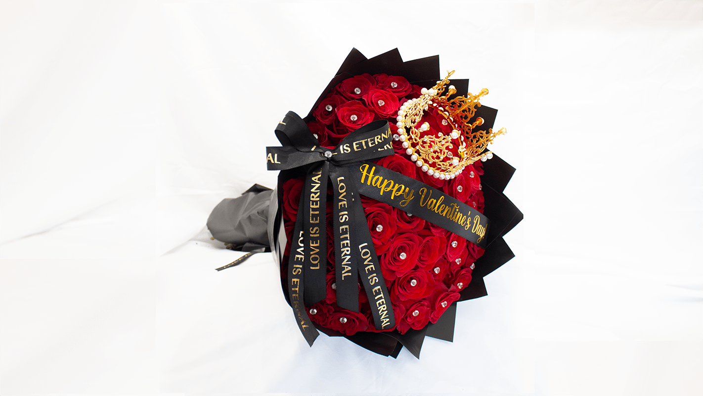 Red rose bouquet with black ribbon and a gold crown decoration