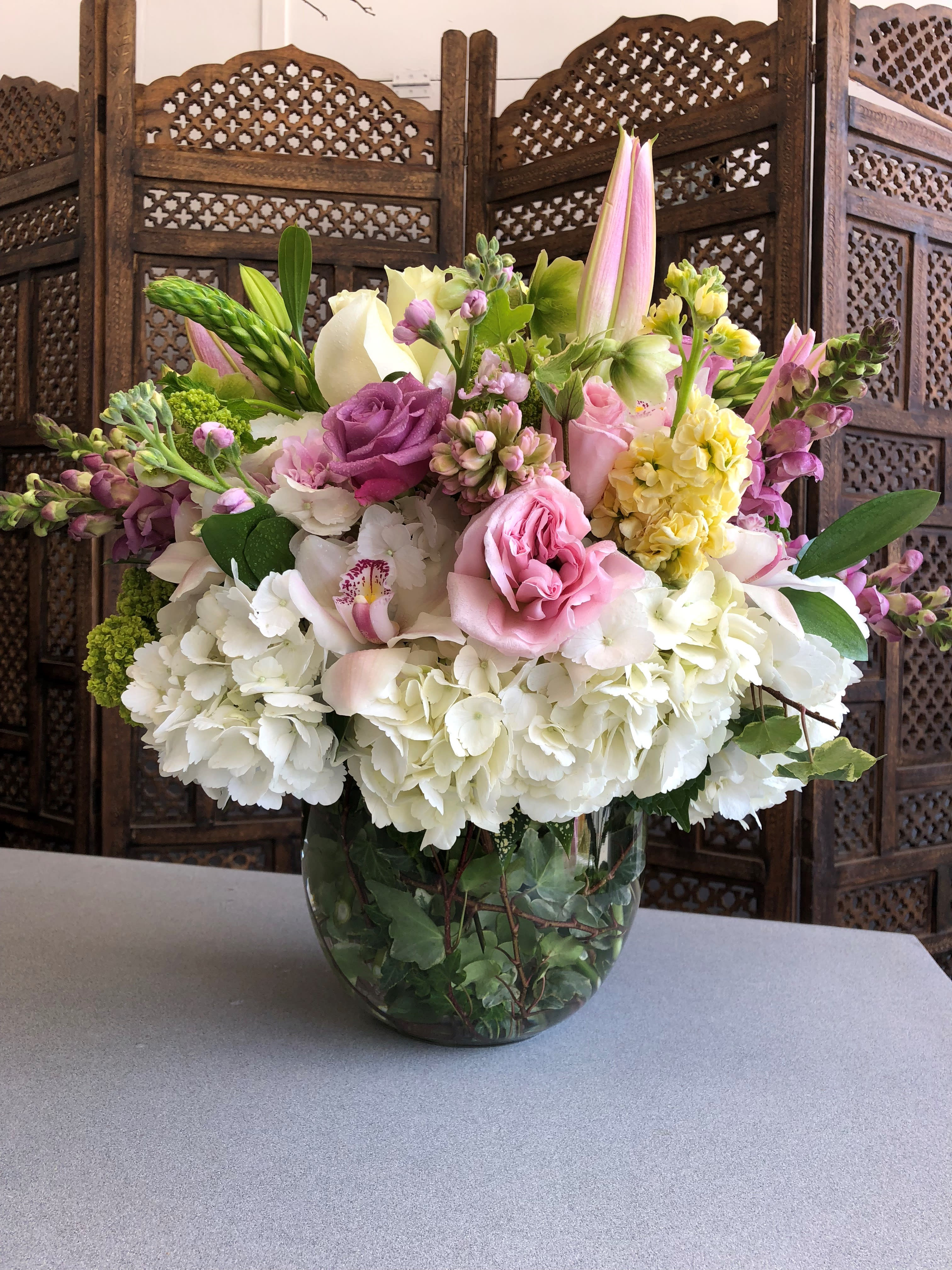 Pink and white mixed flower arrangement in a glass vase