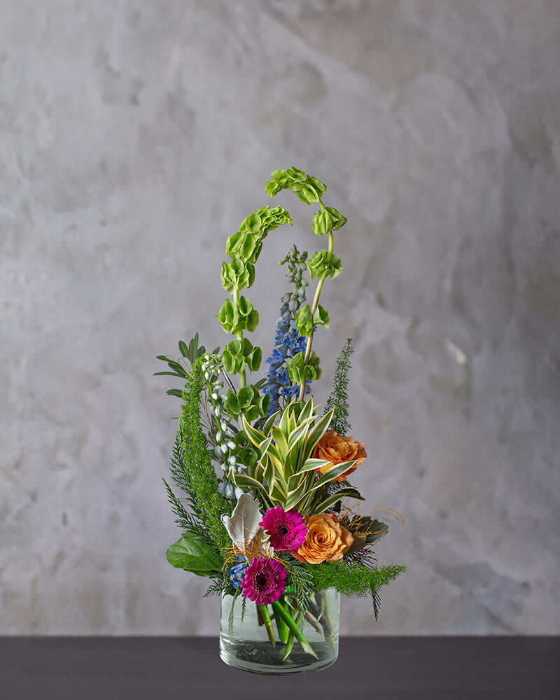 McKenna - The McKenna arrangement reaches new heights of beauty. Hot pink Gerber's and Orange Roses bring a bright pop of color to these gorgeous blooms.