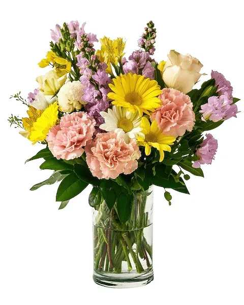 Mixed bouquet of yellow, pink, and white flowers in a clear glass vase
