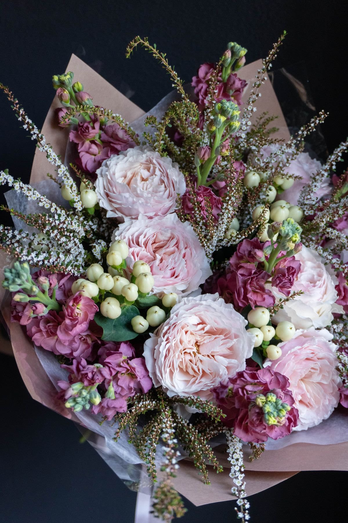 Bouquet of pale pink roses and purple flowers with white berries